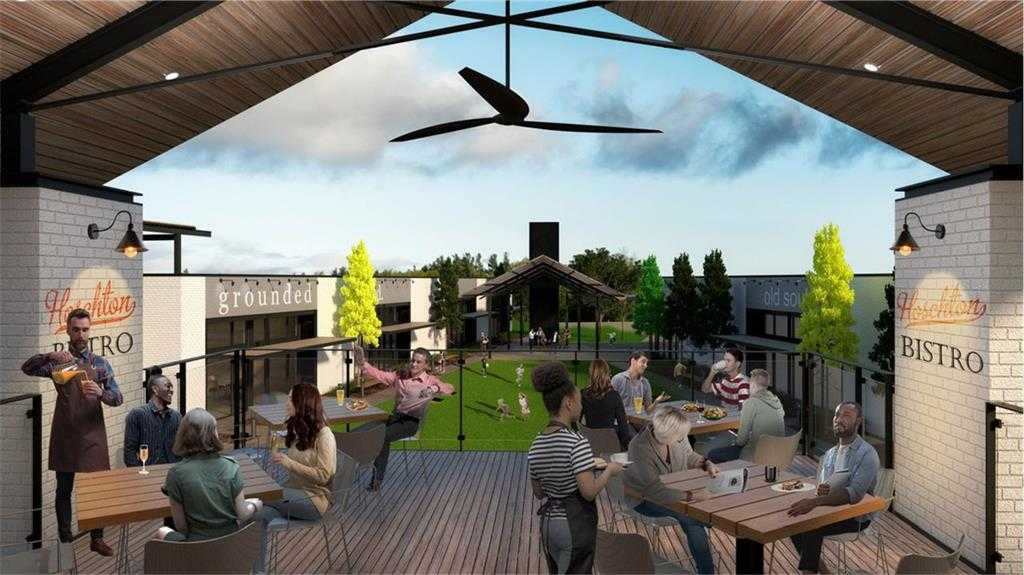 Vibrant Grounded Bistro outdoor dining deck with patrons enjoying meals under ceiling fans, surrounded by greenery in Wehunt Meadows, Hoschton, Georgia