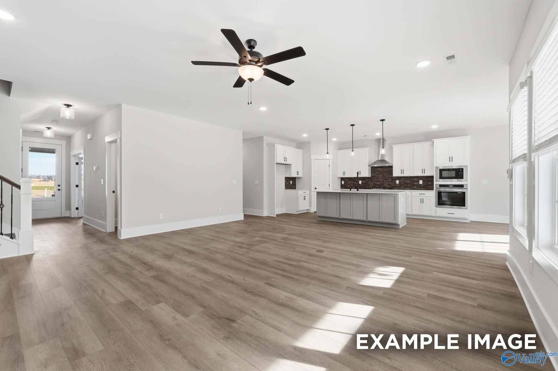 Open-concept living room and gourmet kitchen with white cabinets in The Rockford floor plan, Briercreek, Meridianville, AL.