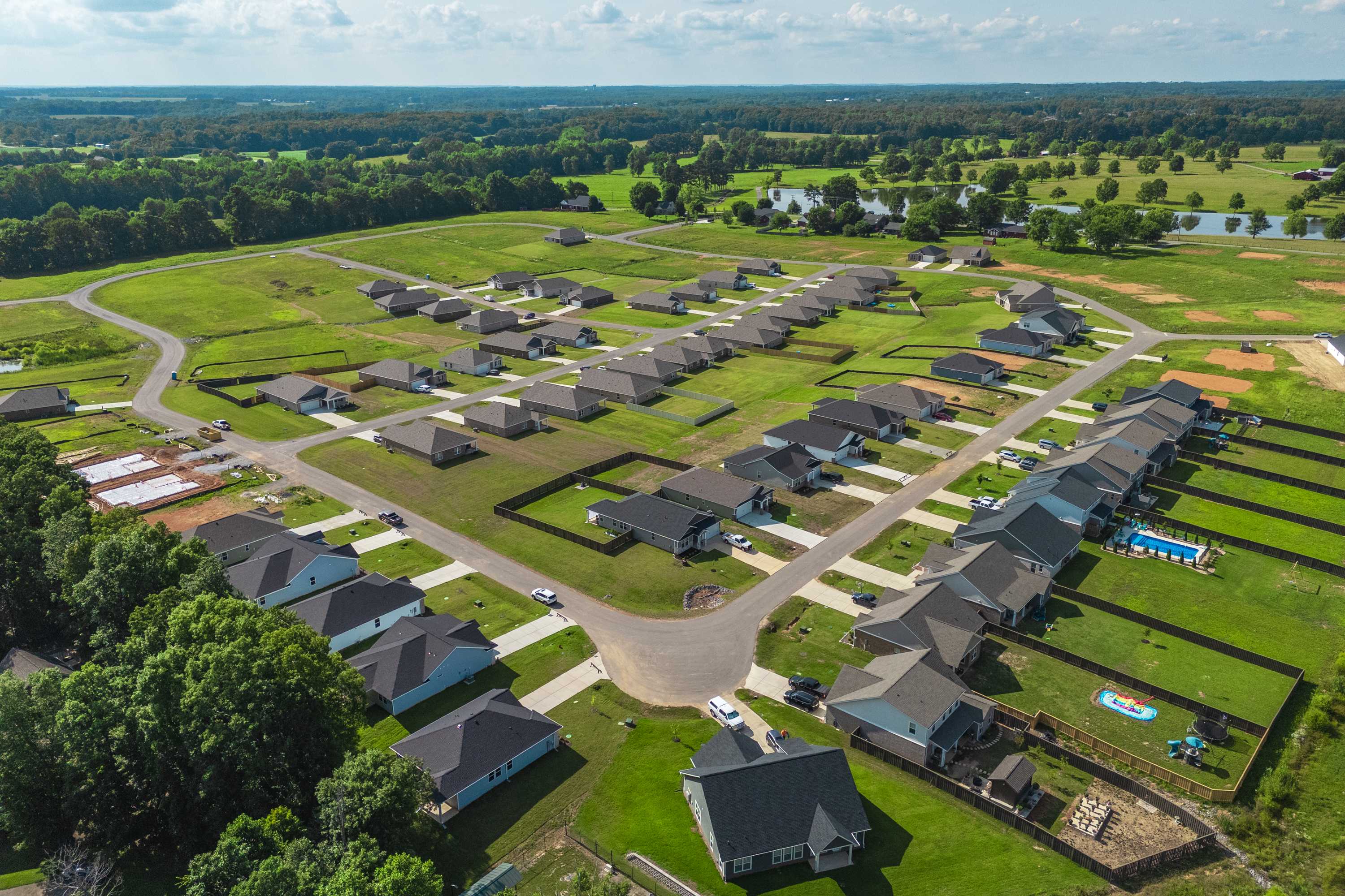 Aerial view of Bailey Park neighborhood in Fayetteville TN with new Davidson Homes, green lawns, ponds and surrounding trees