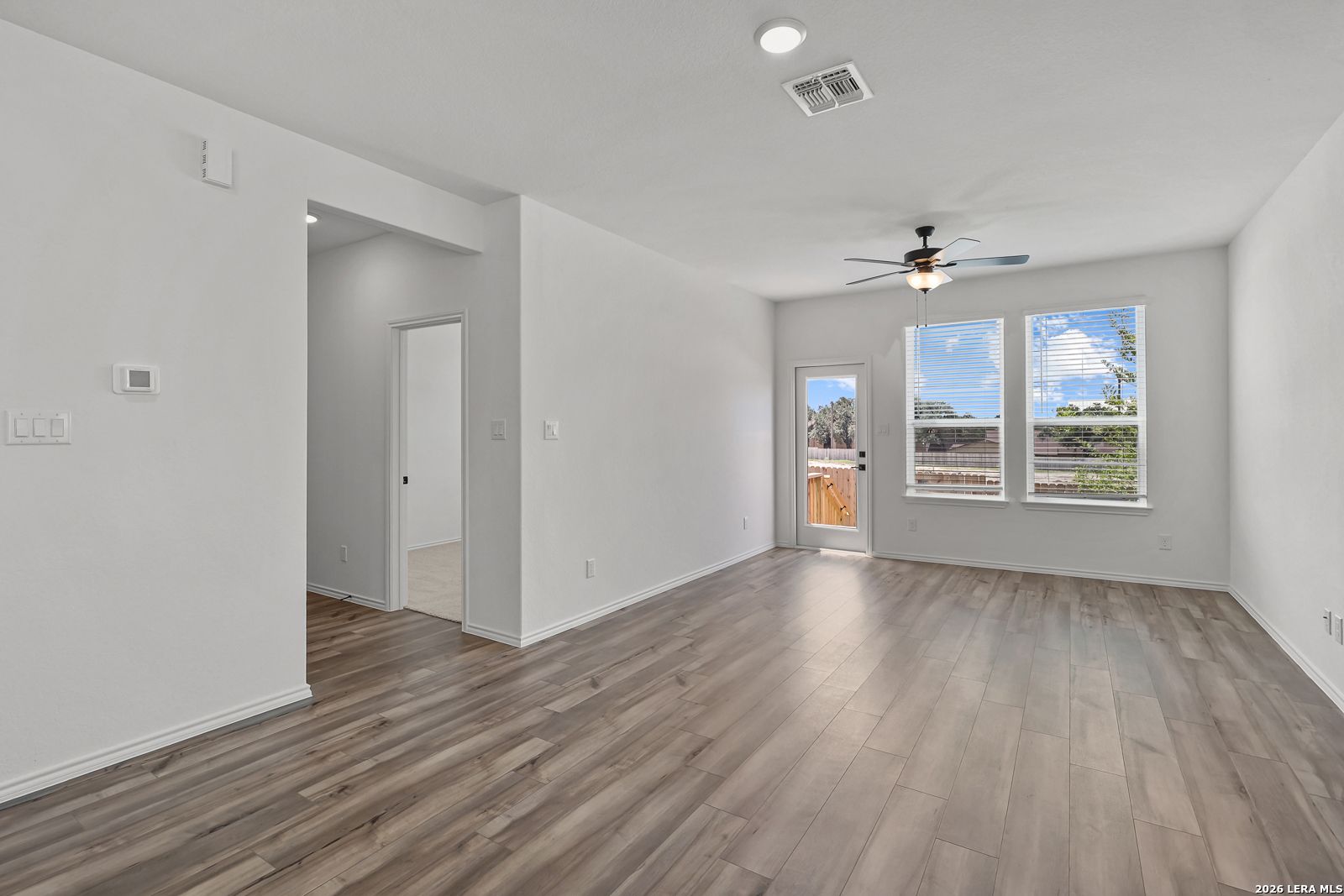 Bright living area with wood-look flooring in The Gillian C floor plan by Davidson Homes in Meadows at Oak Creek, San Antonio.