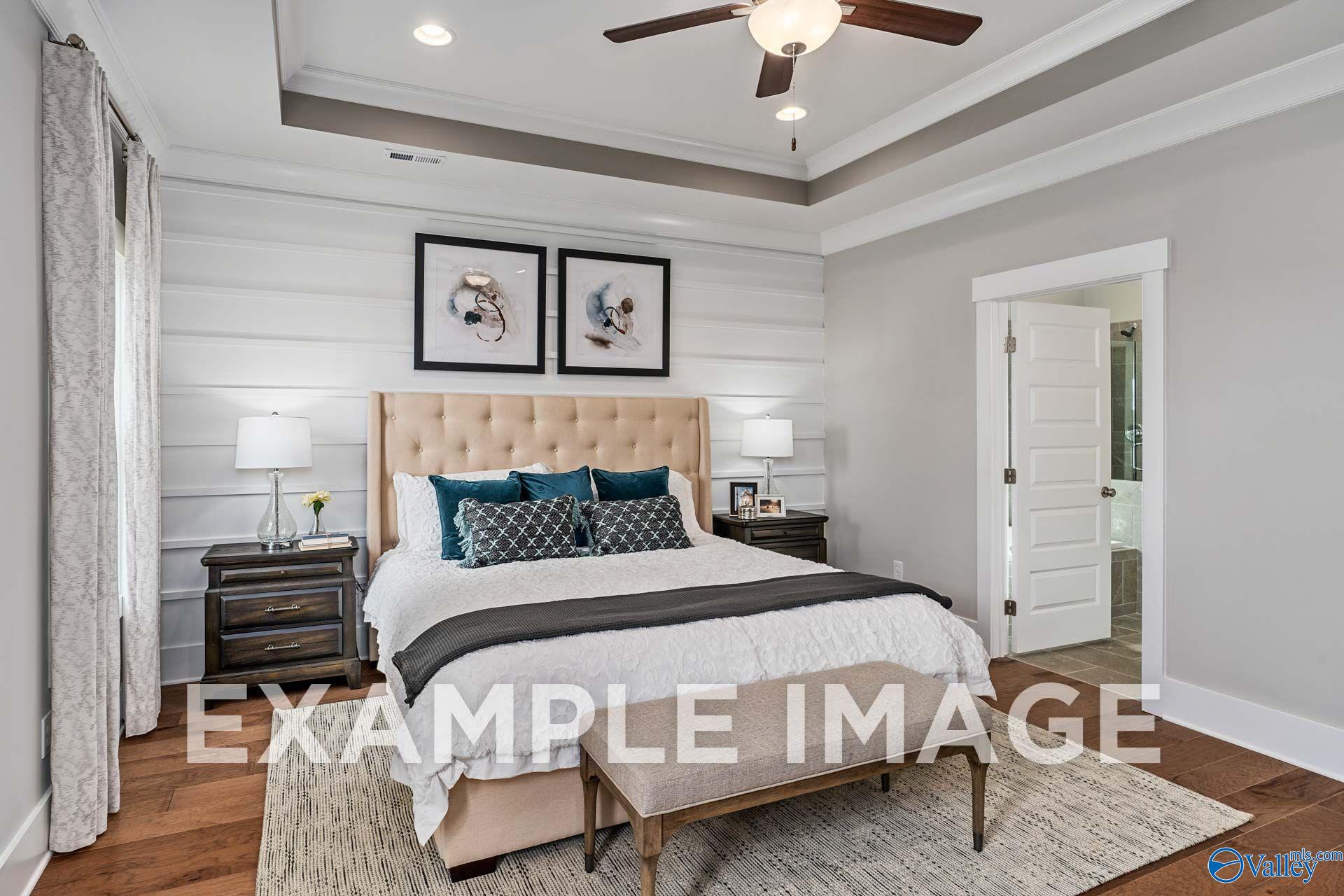 Elegant master bedroom with tray ceiling and shiplap accent wall in Davidson Homes The Harrison, Cain Park, Hartselle, Alabama