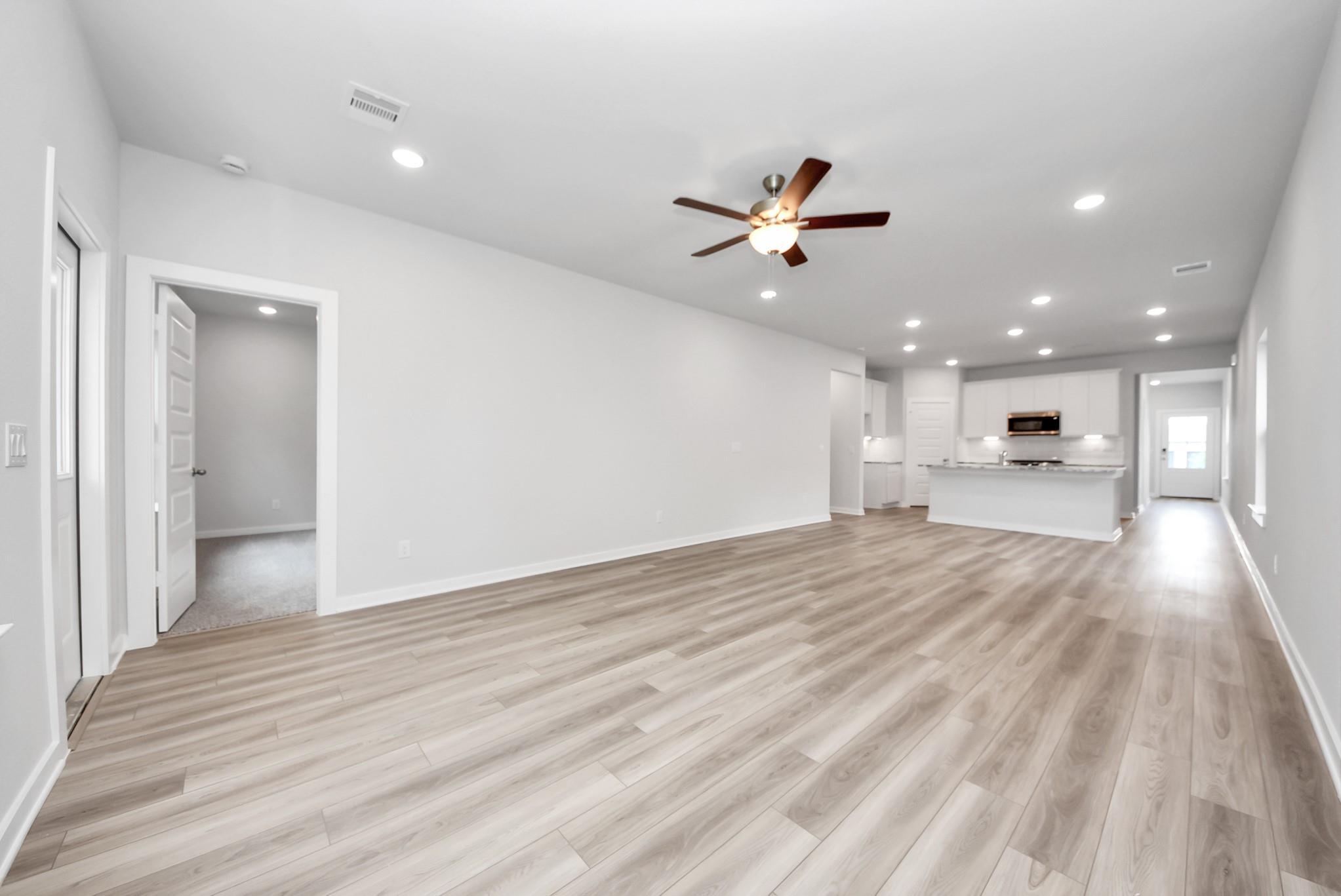 Open-concept living room and kitchen in The Sabine E floor plan at Windmill Estates, Magnolia, Texas.
