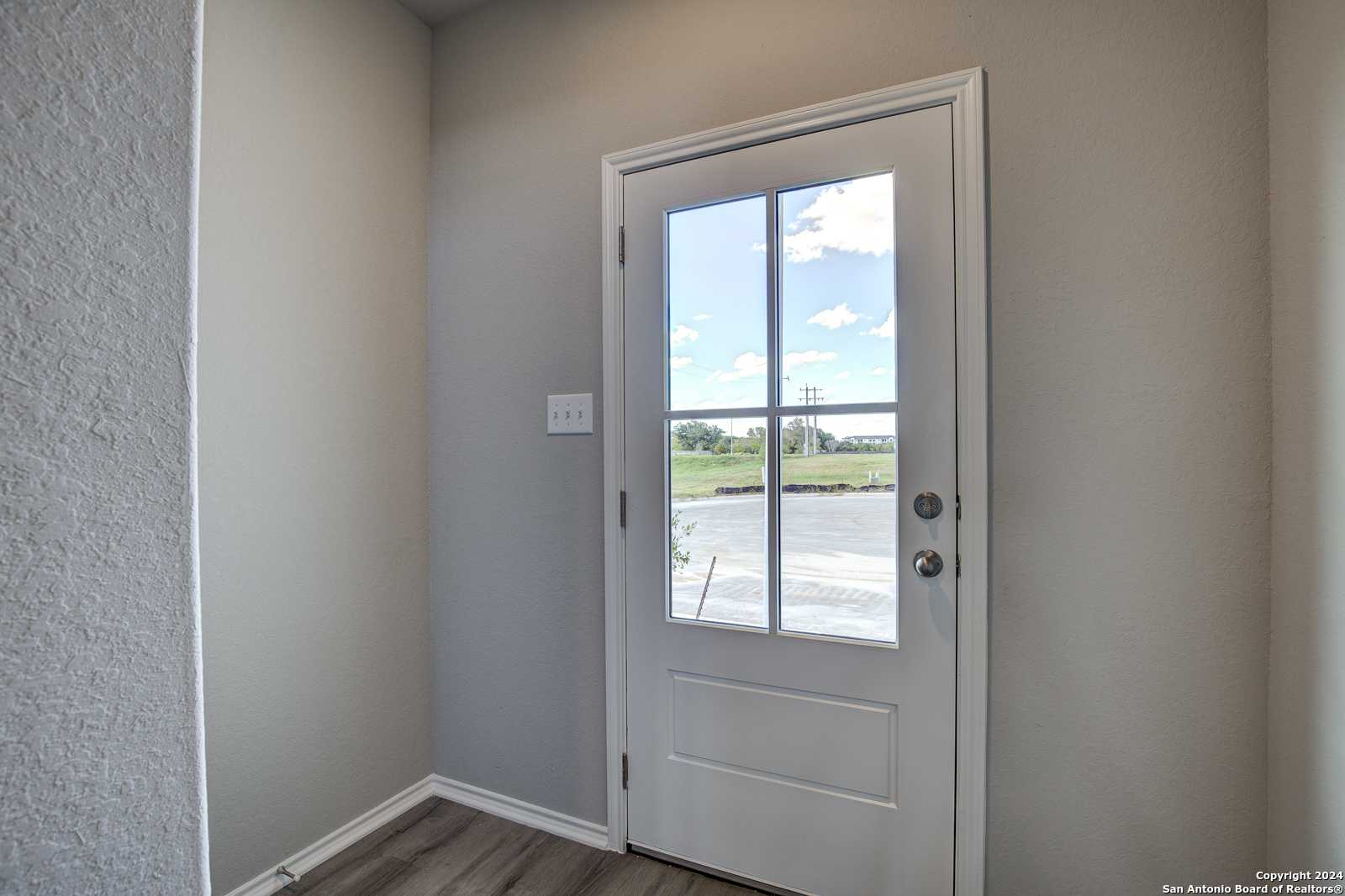White glass-paneled back door with scenic field view and blue sky in Davidson Homes The Blanco C, Applewhite Meadows, San Antonio