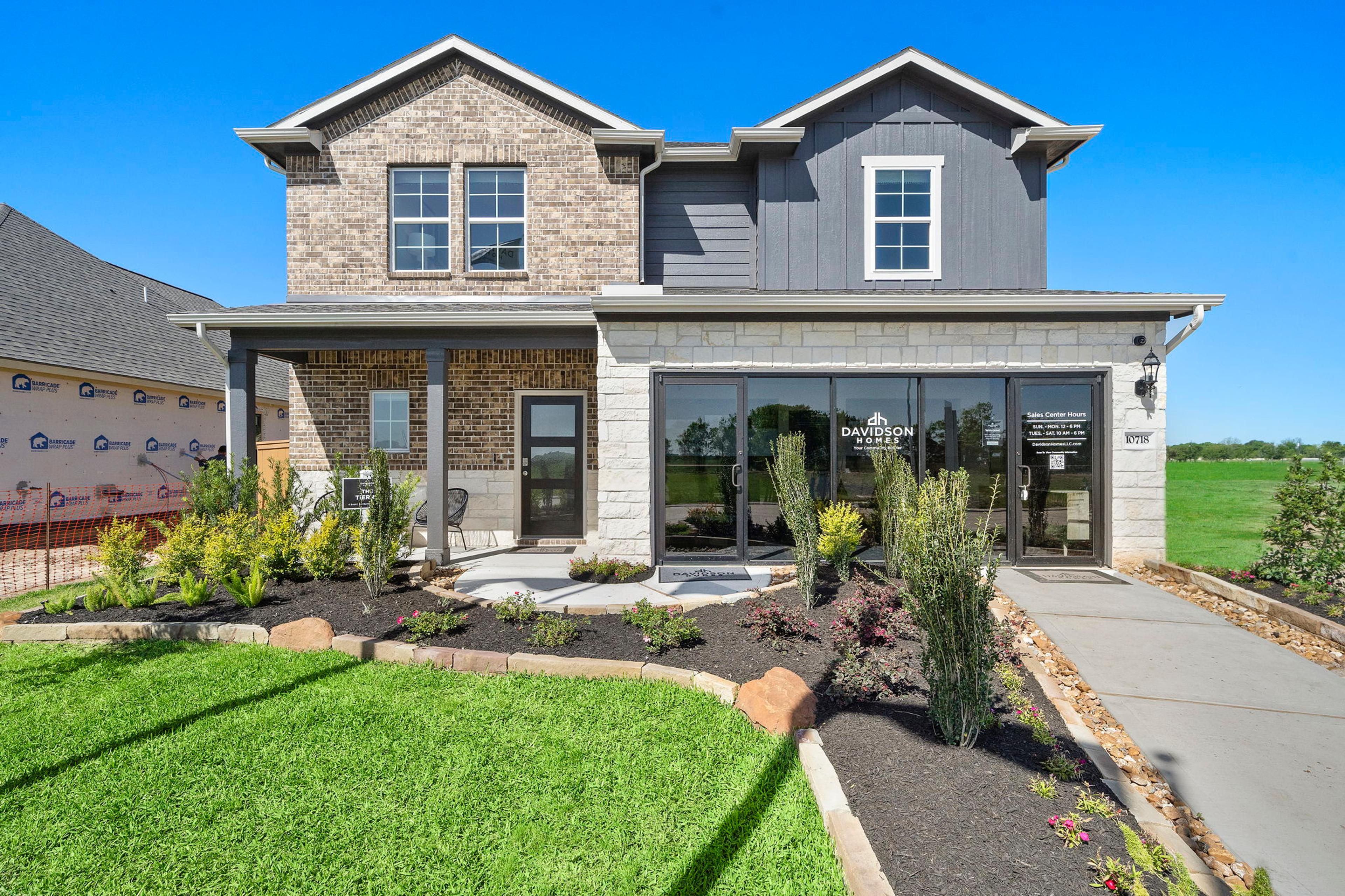 Open-concept kitchen and dining area in Emberly Beasley TX Davidson Homes with hardwood floors, large windows, and modern island
