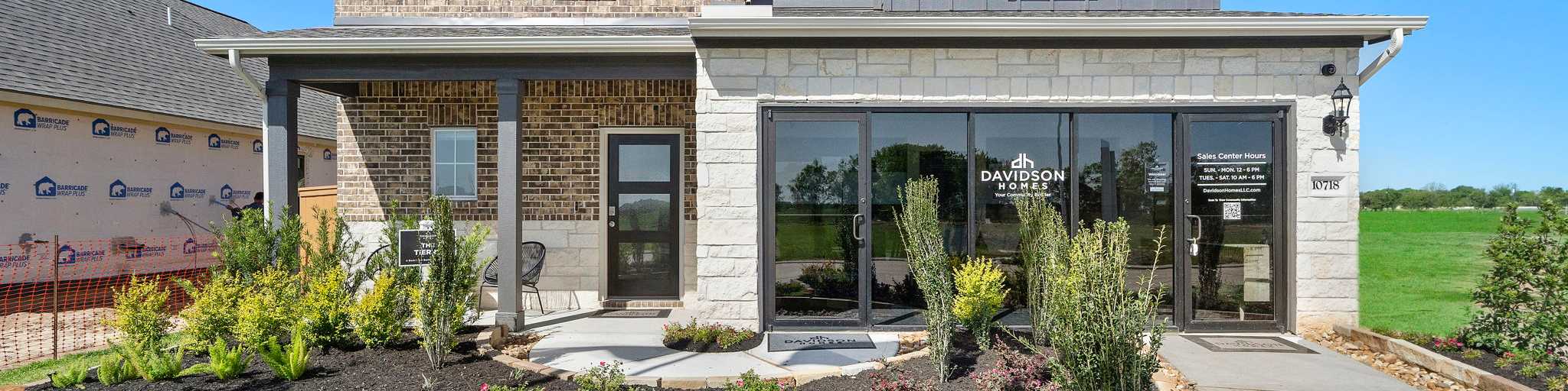 Open-concept kitchen and dining area in Emberly Beasley TX Davidson Homes with hardwood floors, large windows, and modern island