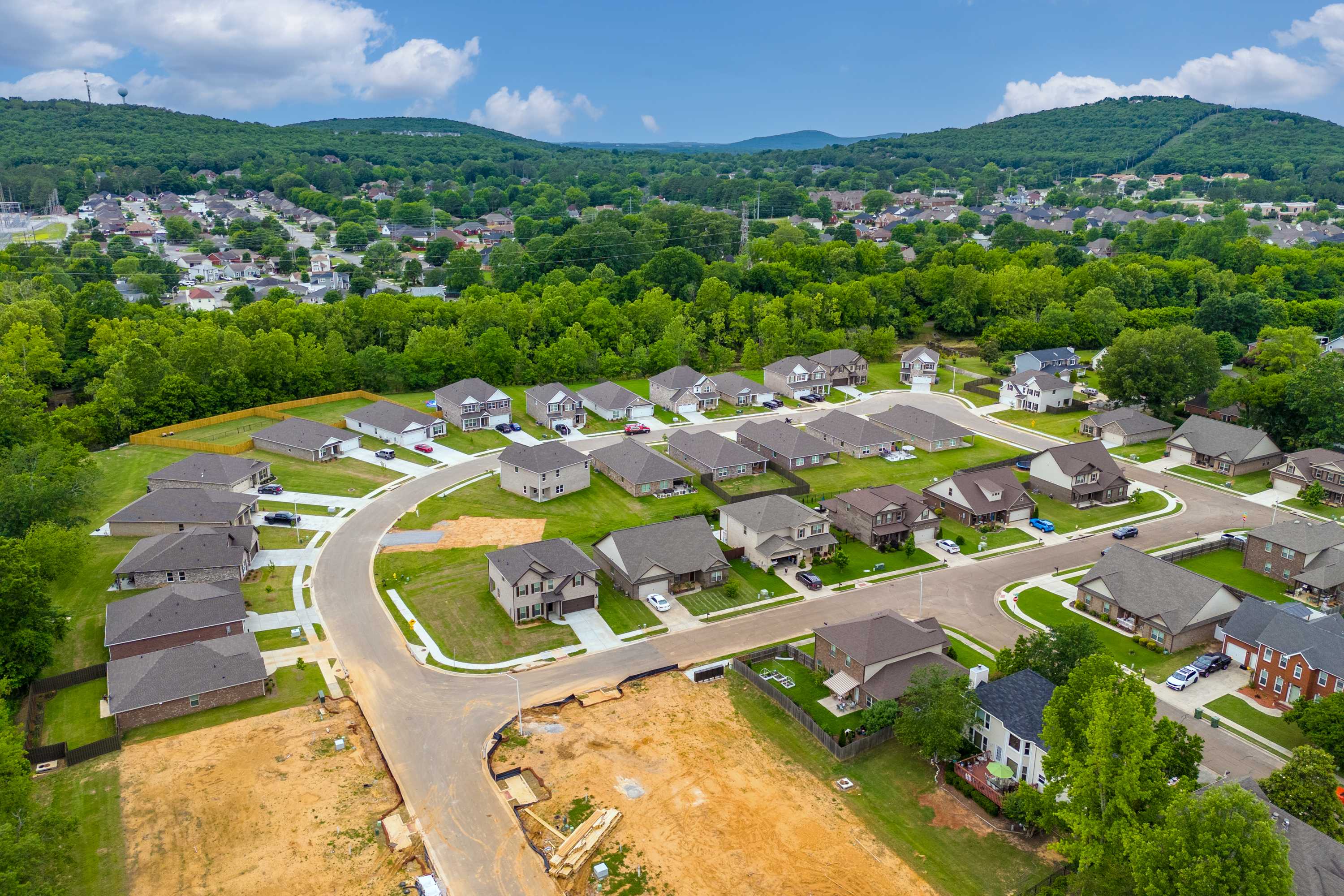 Aerial view of Pavilion neighborhood in Huntsville AL by Davidson Homes featuring new single-family homes, curved streets, and surrounding hills