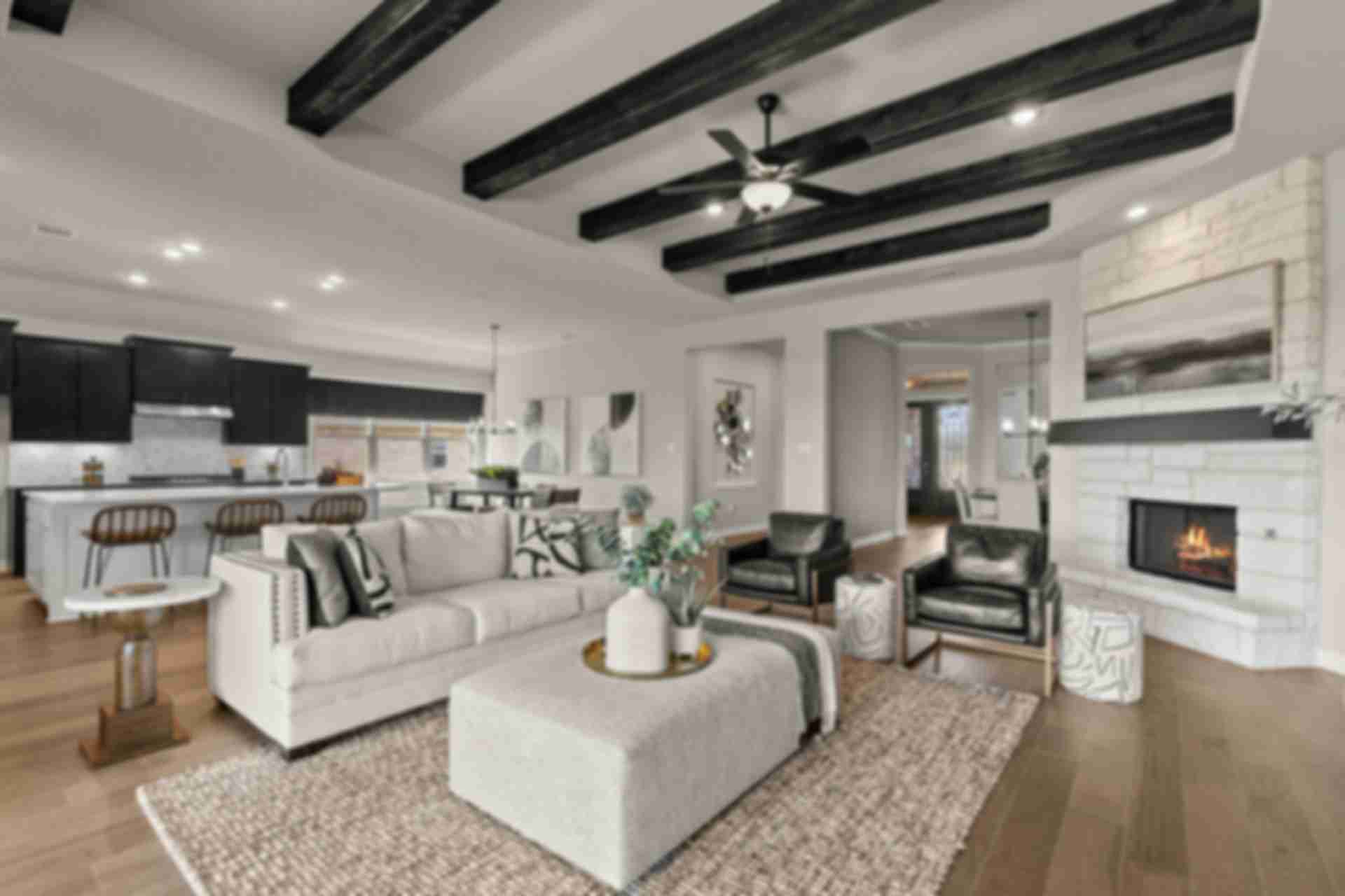 Spacious open-concept living room at Potranco Oaks in Castroville Texas with exposed wood beams, white sofa, and stone fireplace