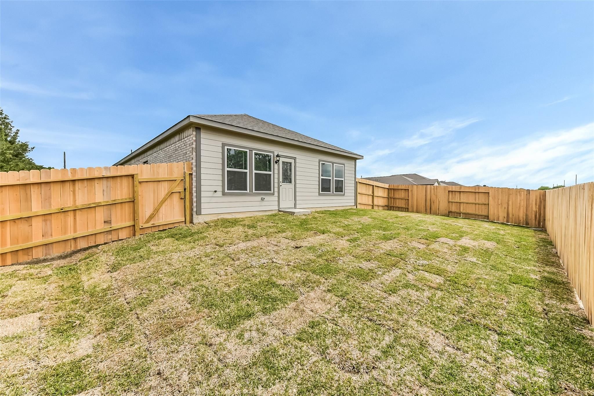 Single-story 3-bedroom Davidson Homes The Frio G with fenced grassy backyard in Windmill Estates, Magnolia, Texas