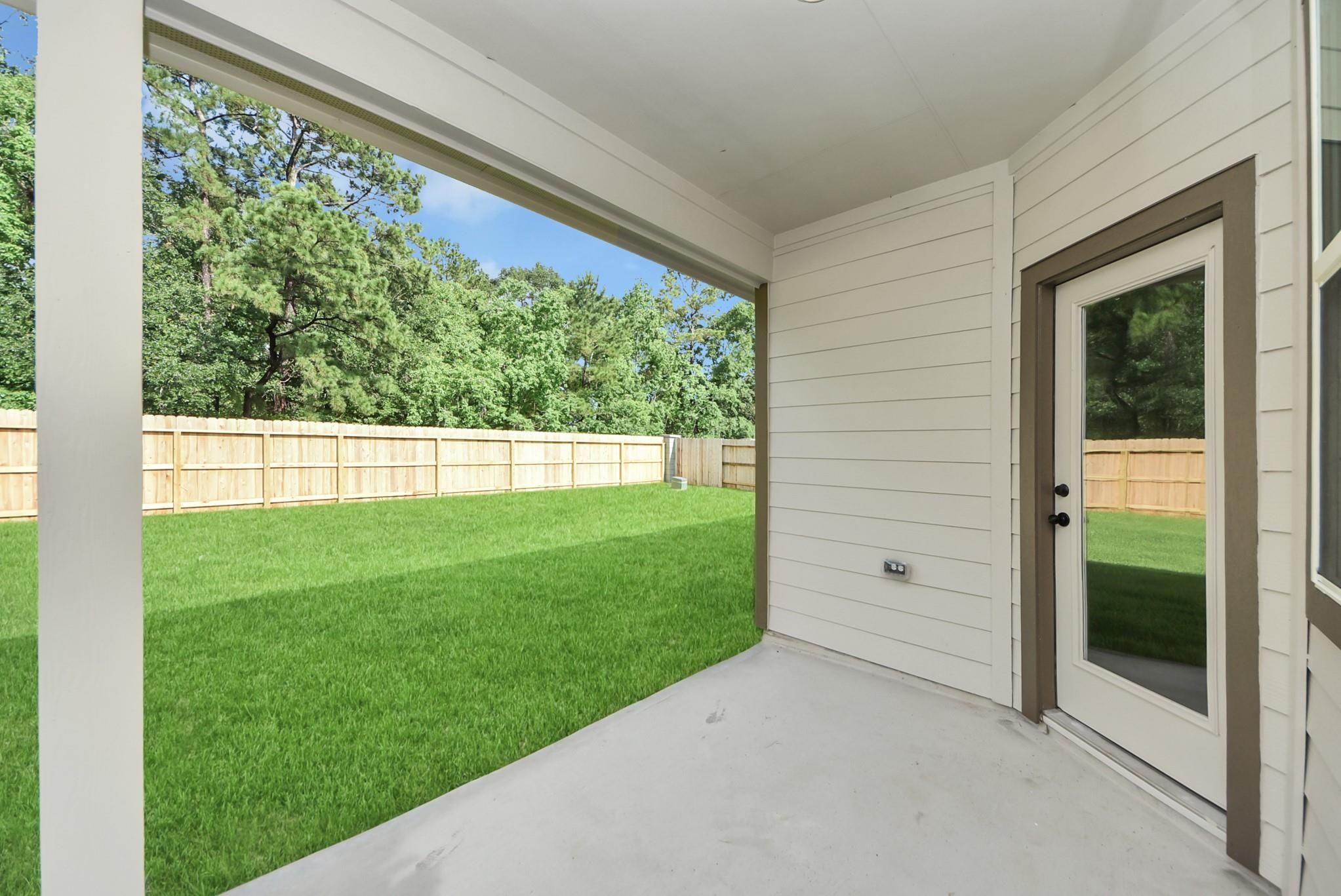 Covered patio and private backyard in The Daphne F floor plan at Sundance Cove, Crosby, Texas.