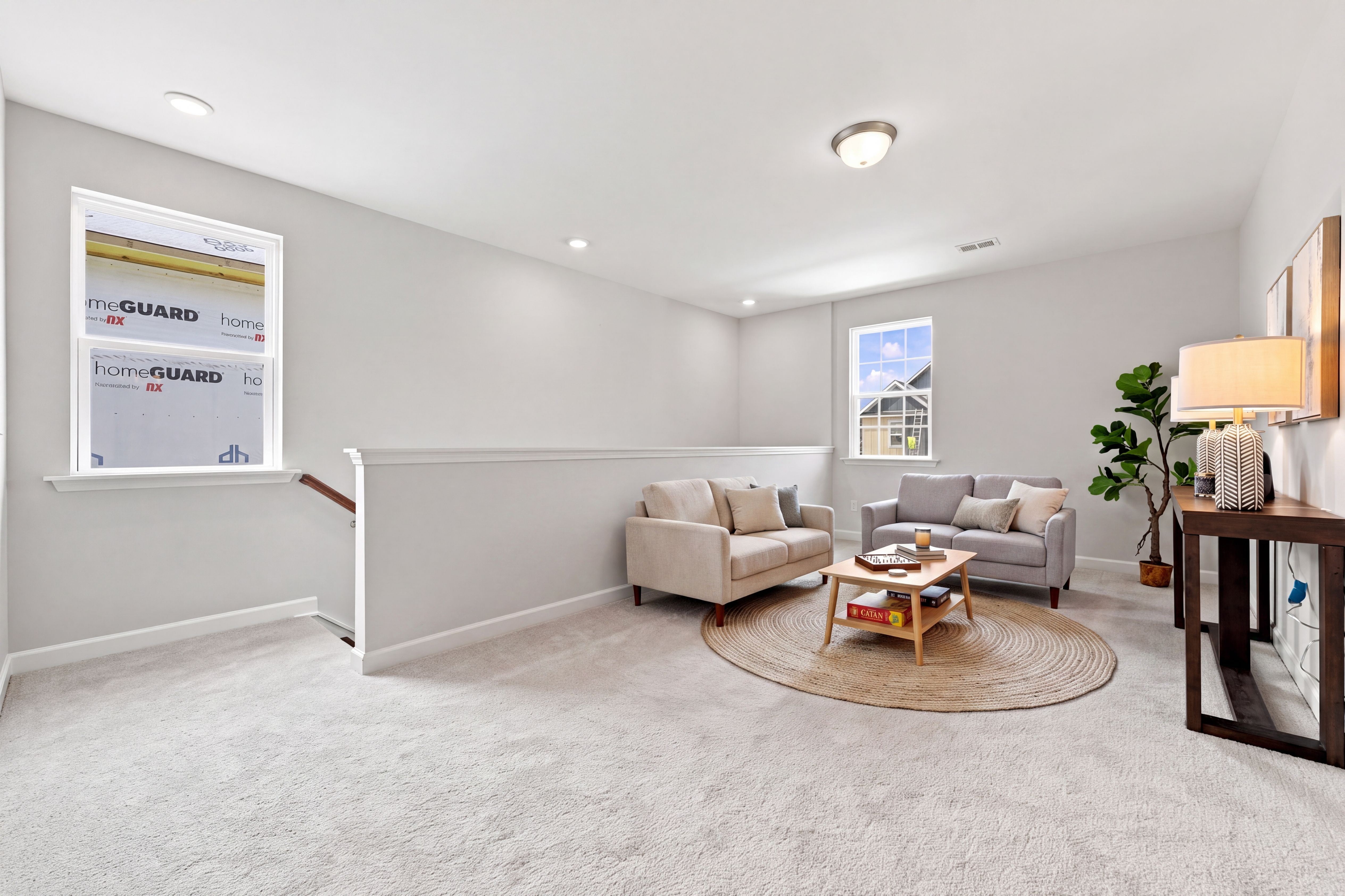 Spacious upper-level loft in The Jordan home design, featuring neutral decor, cozy seating area, and natural lighting.