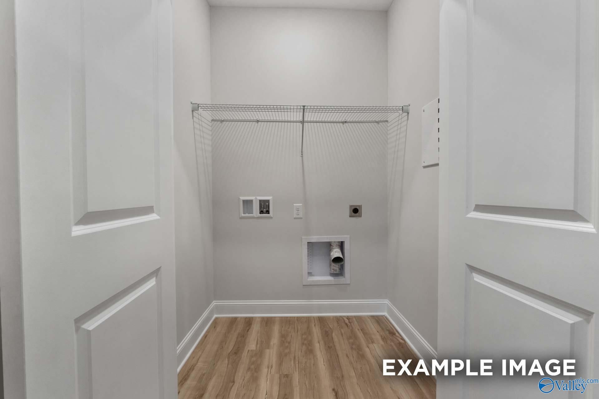 Bright laundry room with wire shelving, washer/dryer hookups and wood floors in Davidson Homes The Cumberland B, Decatur AL