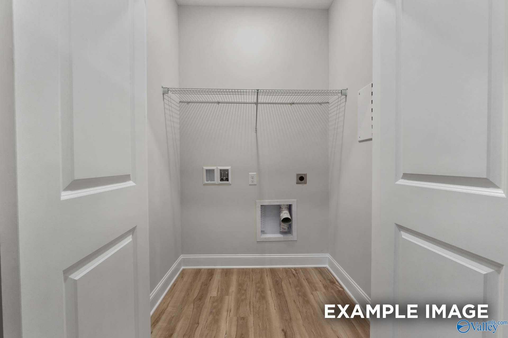 Bright laundry room with wire shelving, washer/dryer hookups and wood floors in Davidson Homes The Cumberland B, Decatur AL