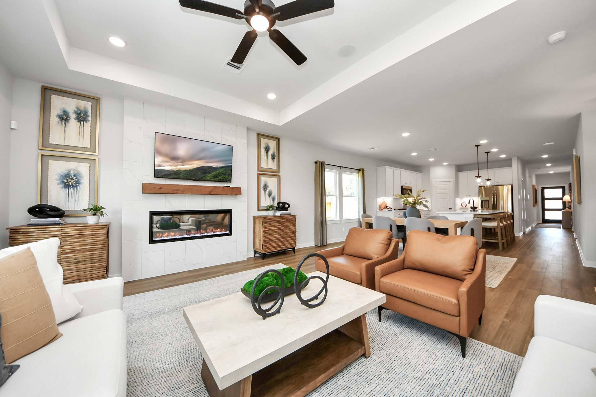 Open-concept living room at Enclave at Newport in Crosby, TX, featuring a modern fireplace and Davidson Homes design.