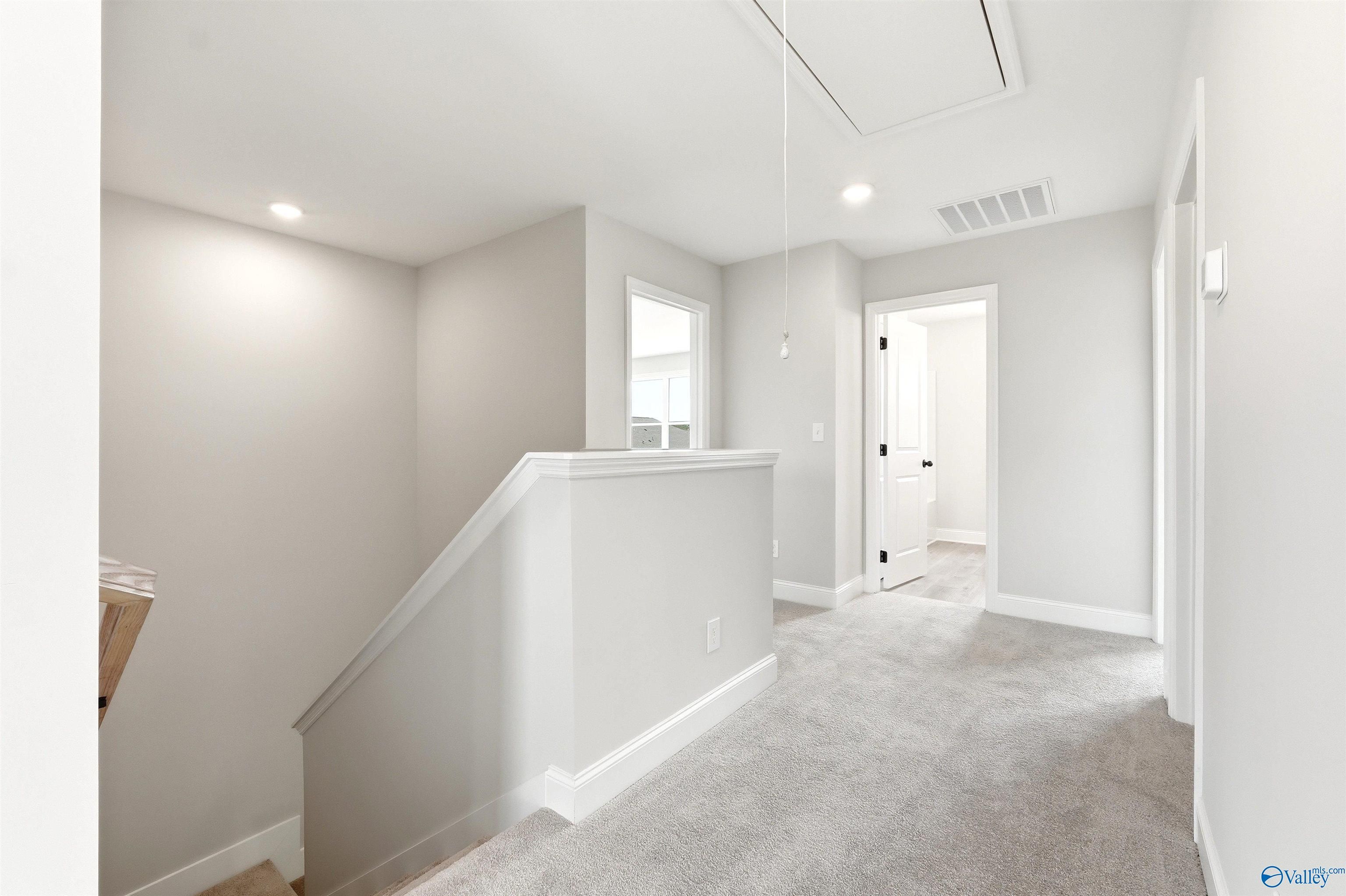 Bright second-floor landing with plush carpeting in The Shelby A floor plan at Wood Trail in Toney, Alabama.