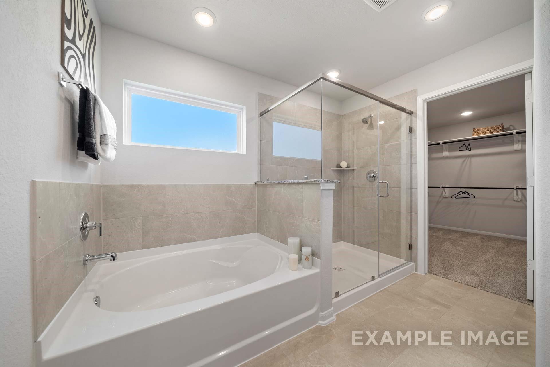 Master bath with garden tub, glass walk-in shower, and walk-in closet in Davidson Homes The Acadia A, Lago Mar, Texas City
