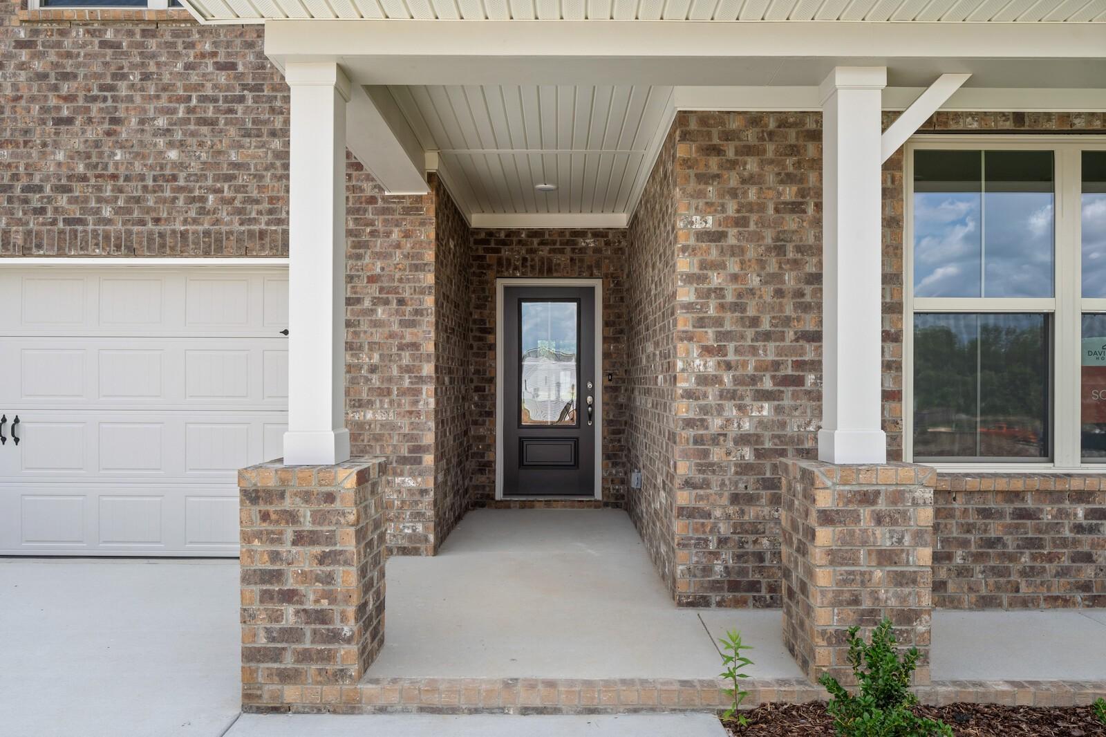 Covered brick front porch and entryway of The Ridgeport C floor plan at Woods Crossing in Gallatin, Tennessee.