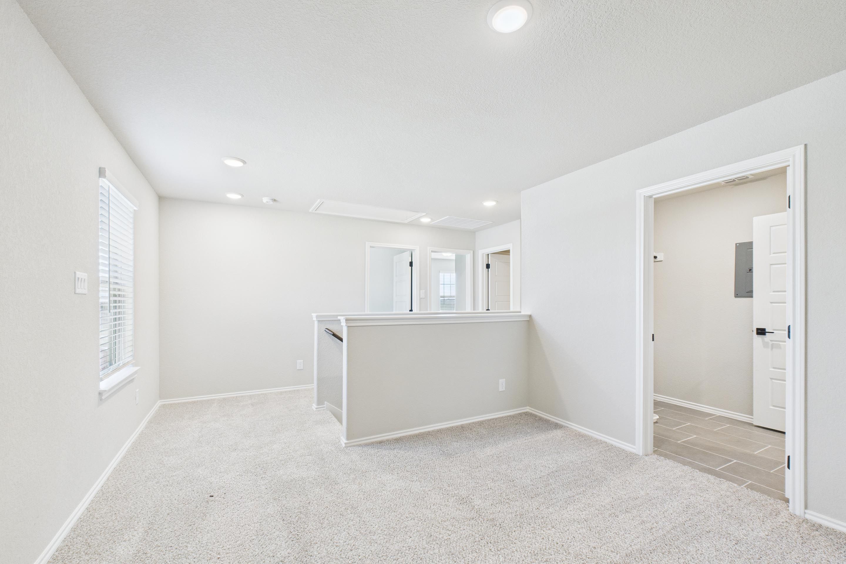 Spacious upstairs loft area in The Charlotte A home design featuring neutral carpet and access to upper floor bedrooms.