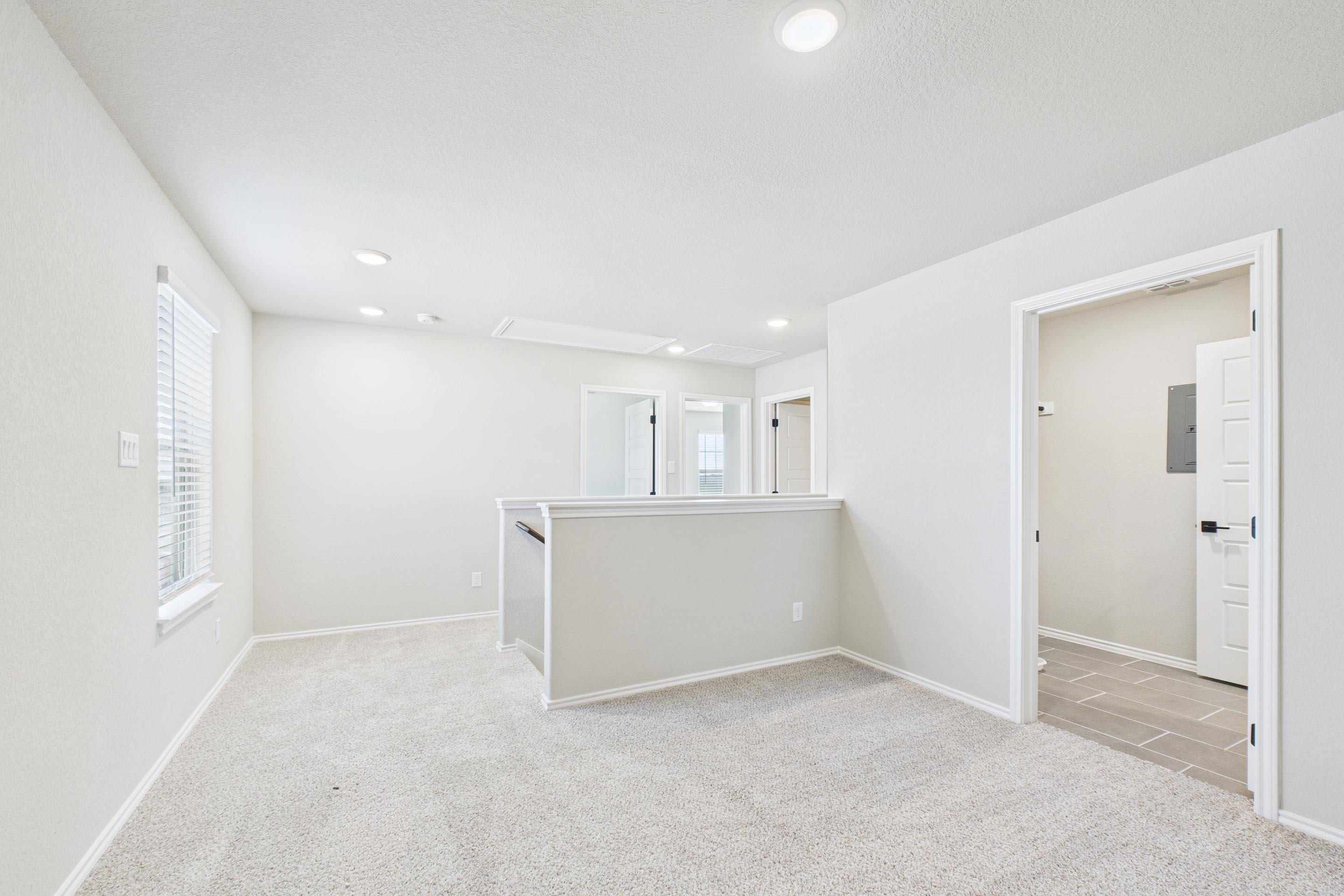 Spacious upstairs loft area in The Charlotte A home design featuring neutral carpet and access to upper floor bedrooms.