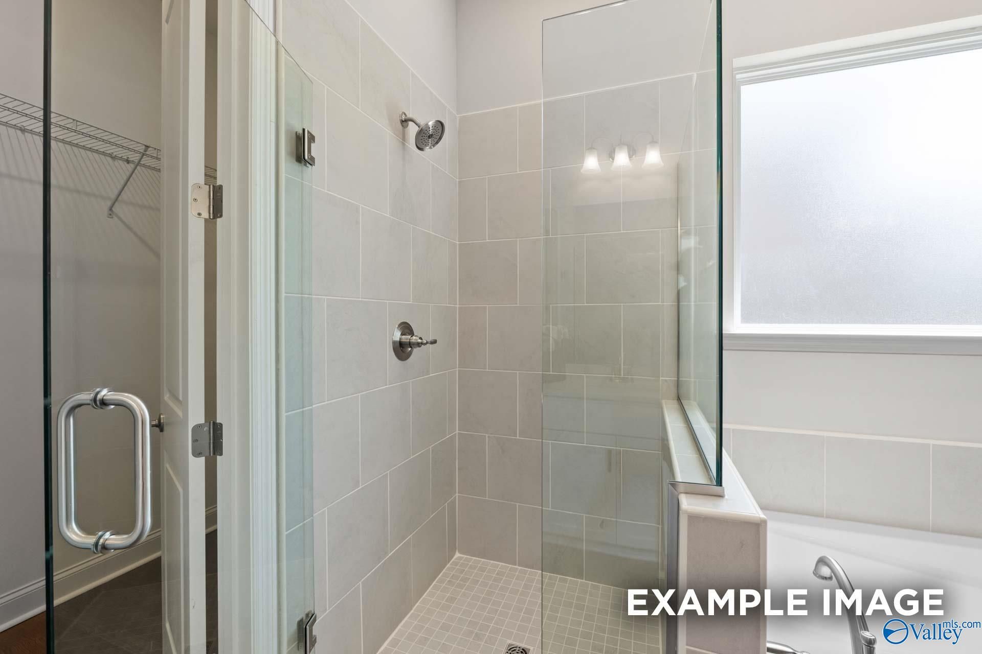 Modern master bathroom featuring frameless glass shower, subway tile walls, and soaking tub in Evermore Homes The Haven E, Owens Cross Roads