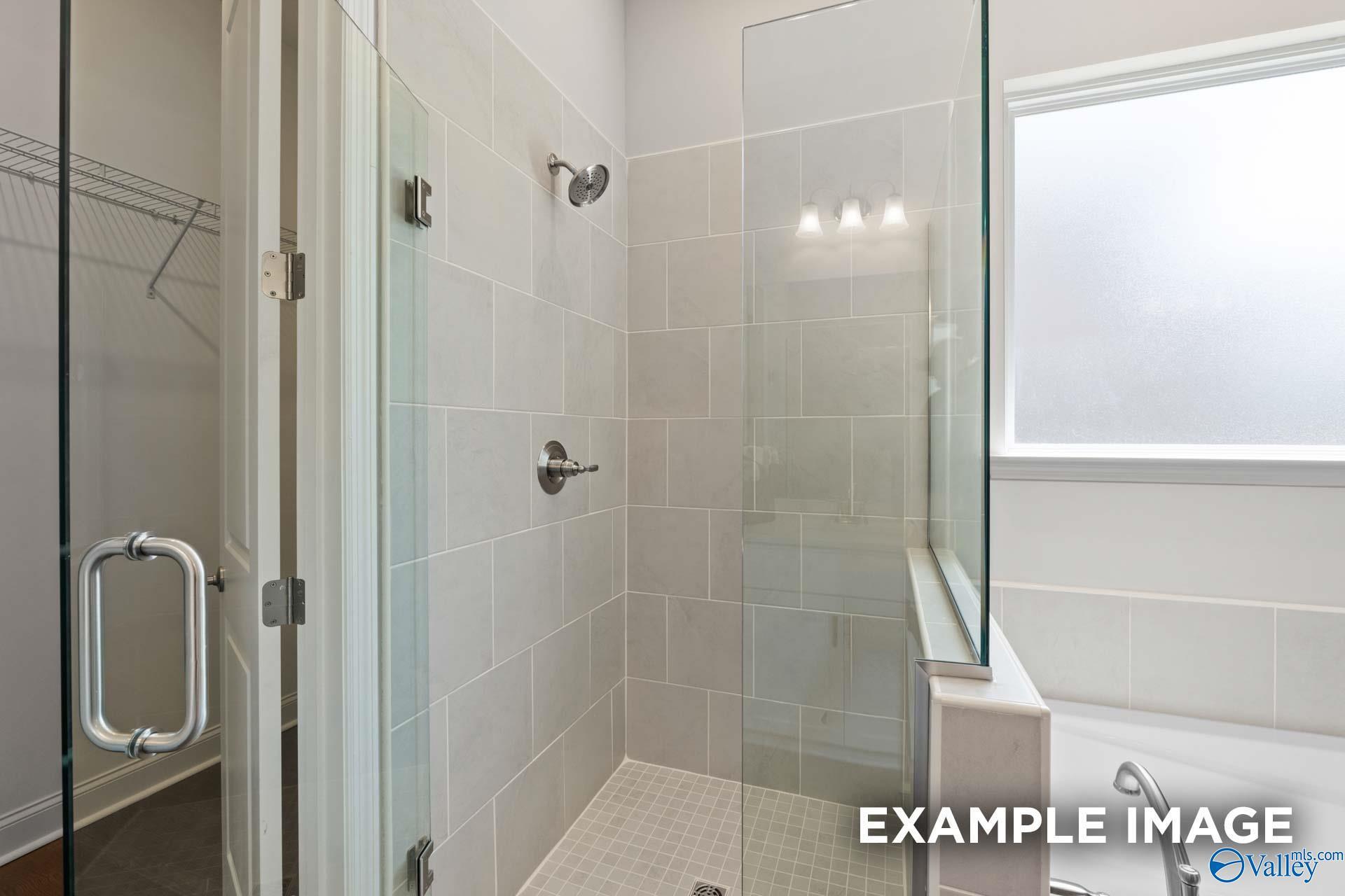 Modern master bathroom featuring frameless glass shower, subway tile walls, and soaking tub in Evermore Homes The Haven E, Owens Cross Roads