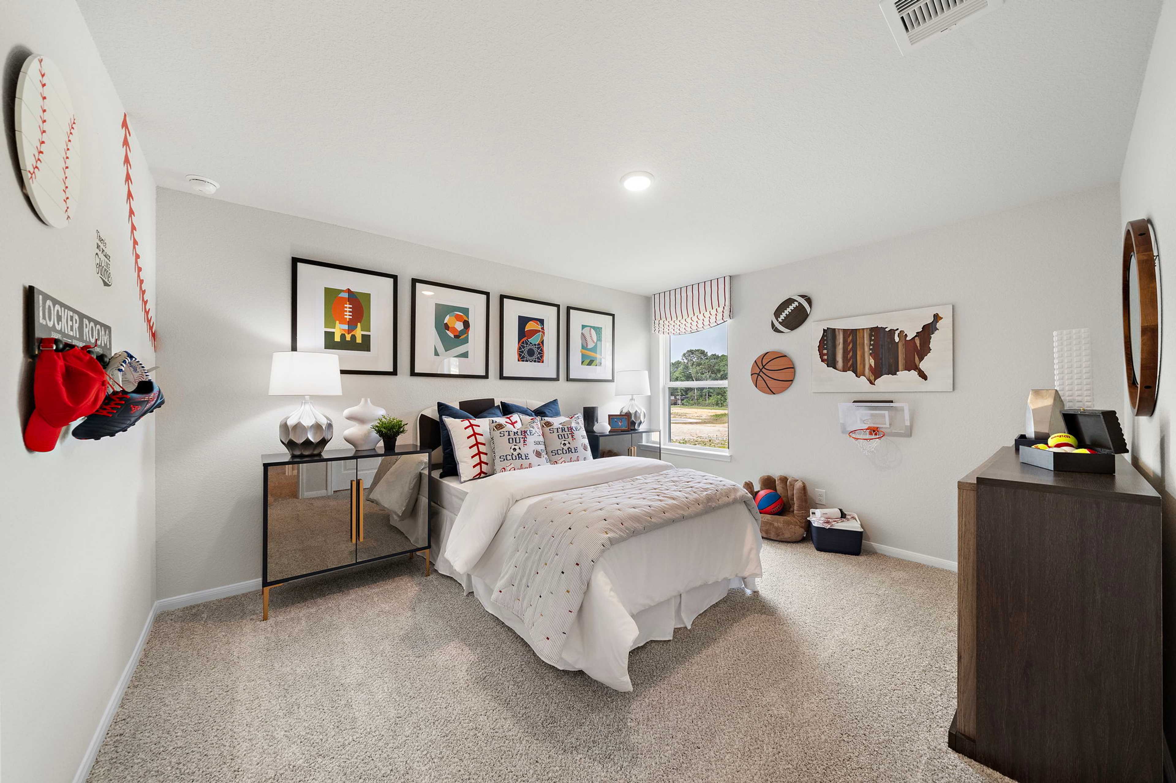 Sports-themed bedroom at Liberty Estates in Cleveland Texas by Davidson Homes with white bedding bed and baseball football decor