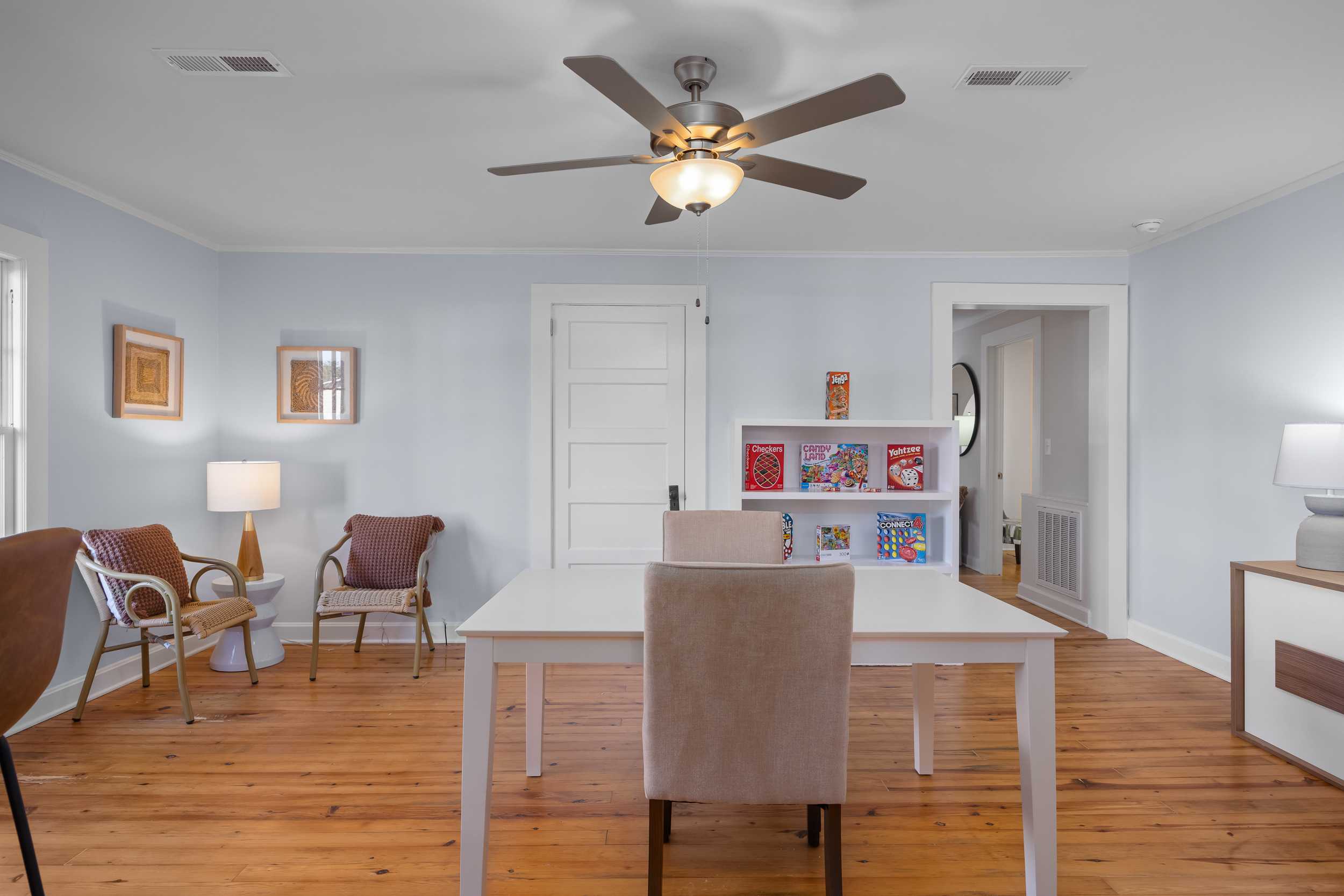 Cozy home office at Stagecoach Corner in Mebane NC with hardwood floors, ceiling fan, bookshelves, and armchairs