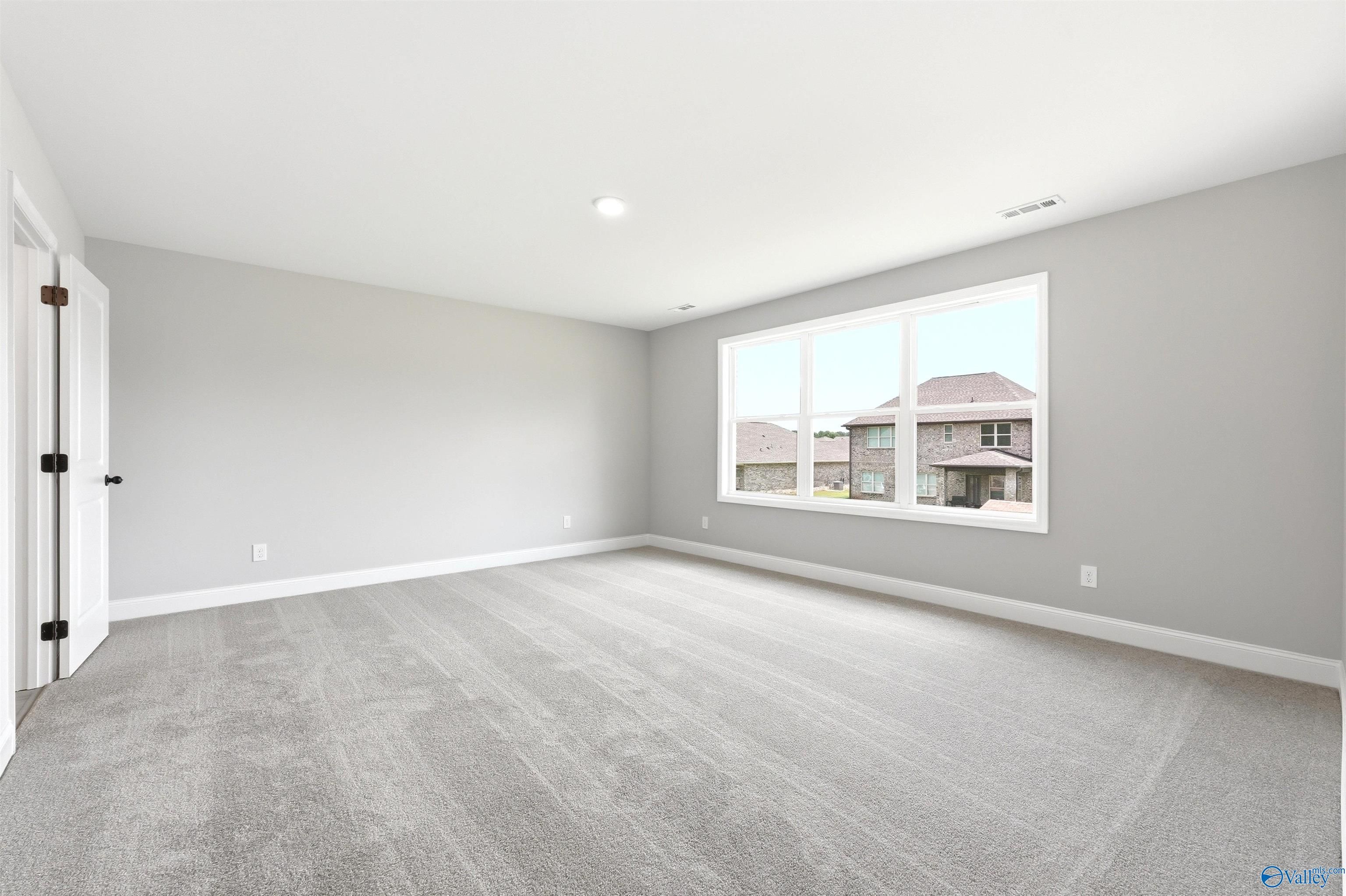 Spacious, sunlit bedroom with neutral gray walls and plush carpeting in The Shelby A floor plan at Wood Trail, Toney, AL.
