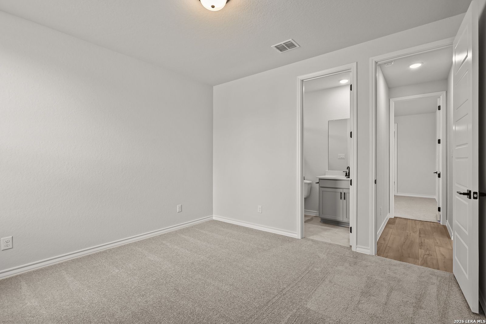 Spacious carpeted bedroom with private bathroom access in Davidson Homes The Oxford F plan, Potranco Oaks, Castroville, Texas