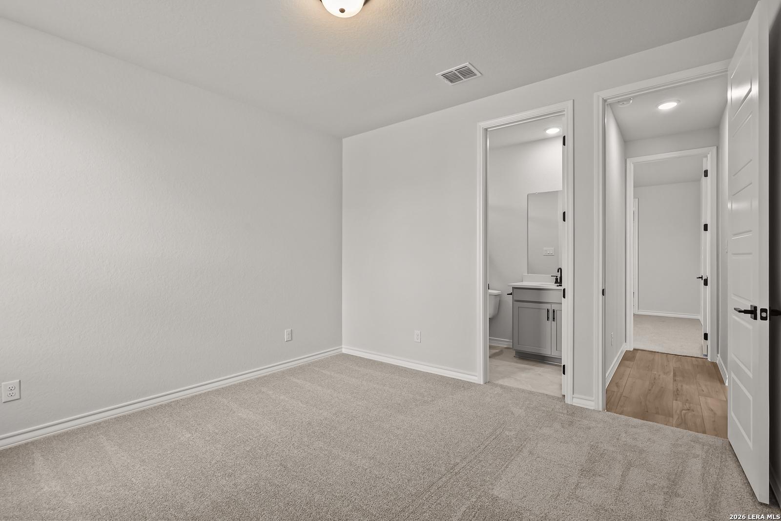 Spacious carpeted bedroom with private bathroom access in Davidson Homes The Oxford F plan, Potranco Oaks, Castroville, Texas