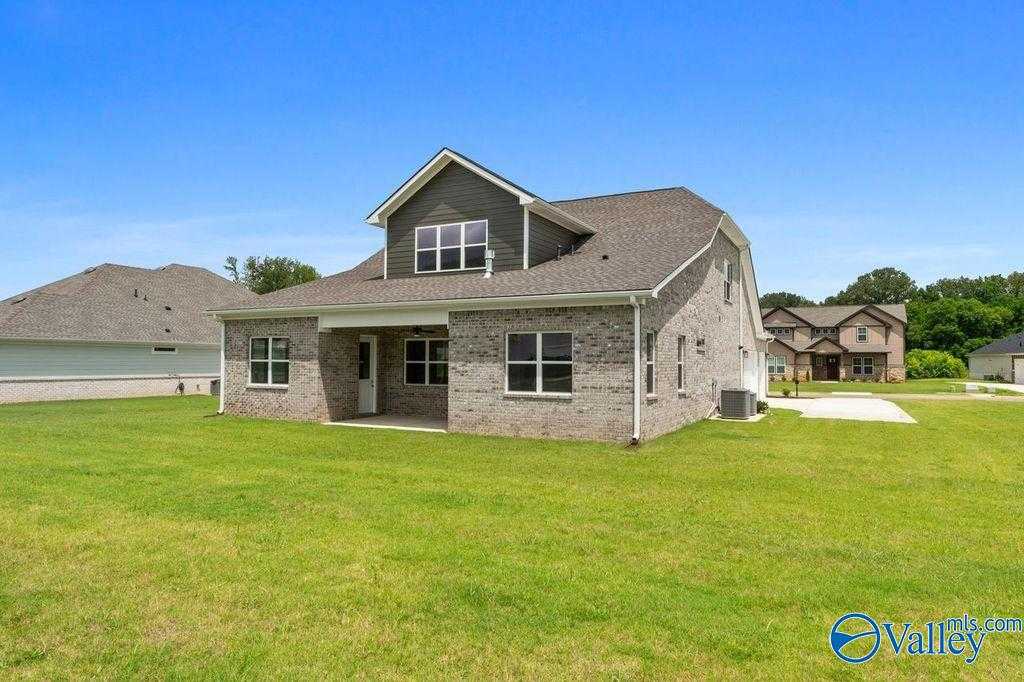 Modern 1.5-story brick home with covered front porch, large windows, and green lawn in The Meadows at Hampton Cove, Owens Cross Roads, Alabama