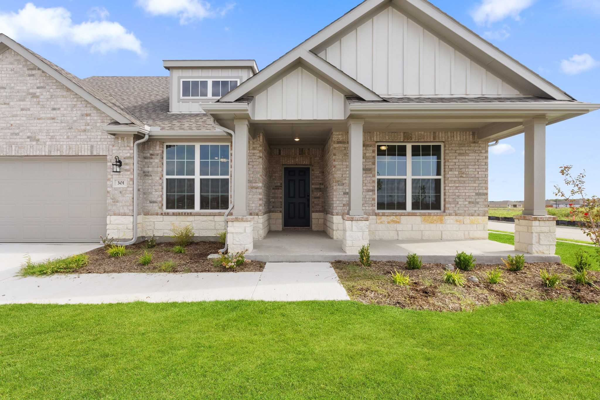 Modern brick facade of The Harrison D 4-bedroom ranch home with 3-car garage in Waverly Estates, Josephine, Texas