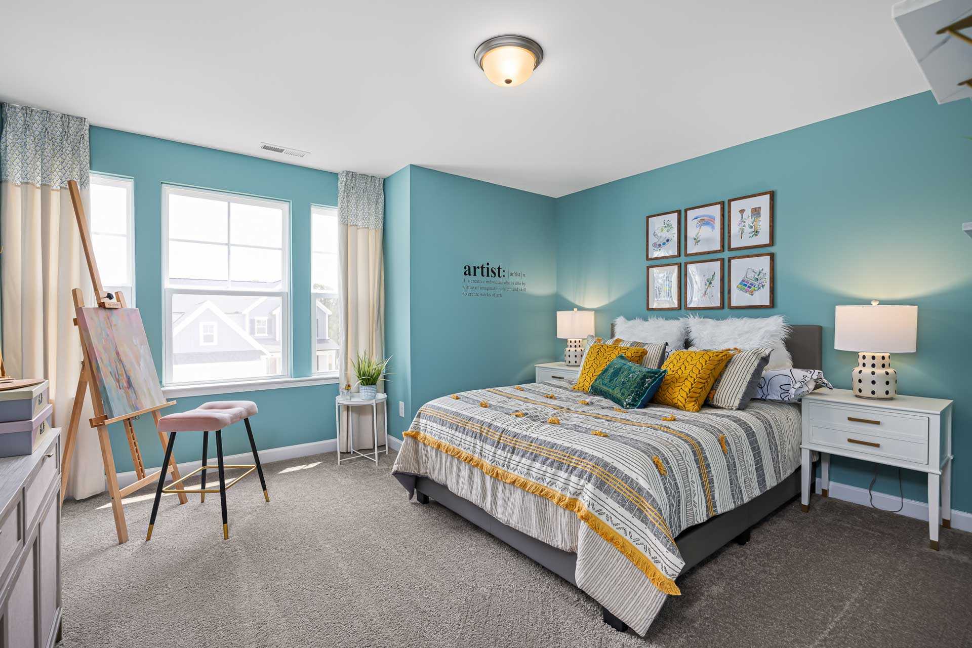 Cozy artist's bedroom in Beverly Place, Four Oaks NC with teal walls, easel, striped duvet bed, and wall art