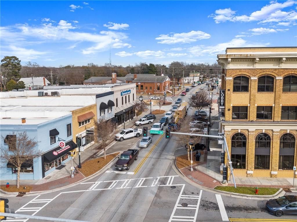 Aerial view of historic downtown Winder, Georgia, with brick buildings, shops, parked cars, and tree-lined streets near Cedar Farms