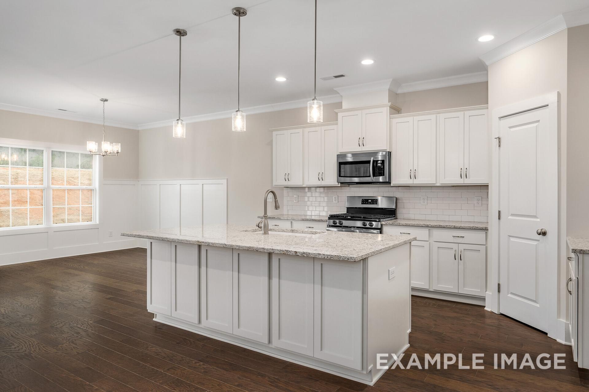 Spacious gourmet kitchen in The Rockford by Davidson Homes with white shaker cabinets, quartz island, stainless appliances
