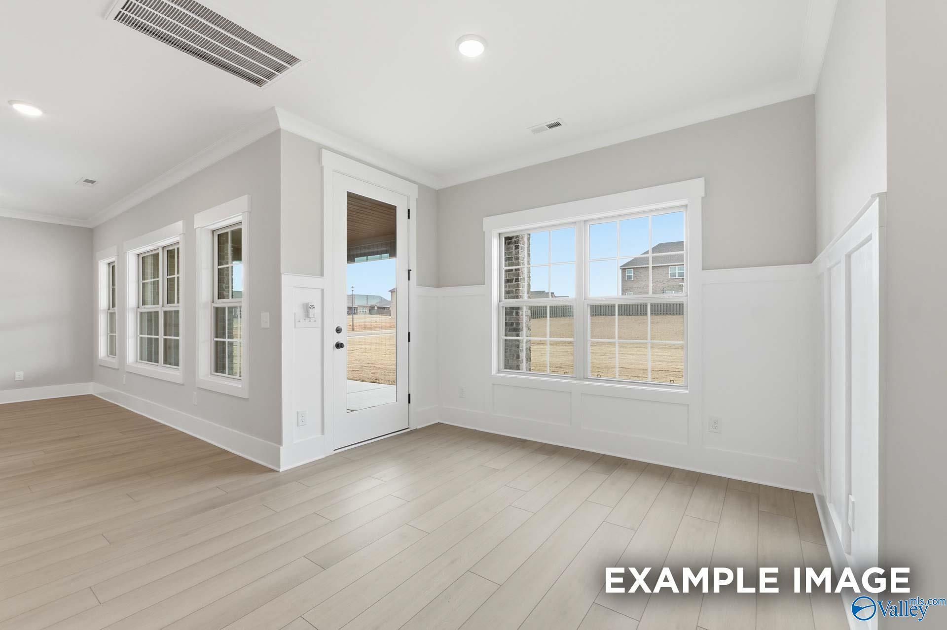 Bright sunroom with large windows, wainscoting, hardwood floors in Davidson Homes The Emory, Decatur, Alabama