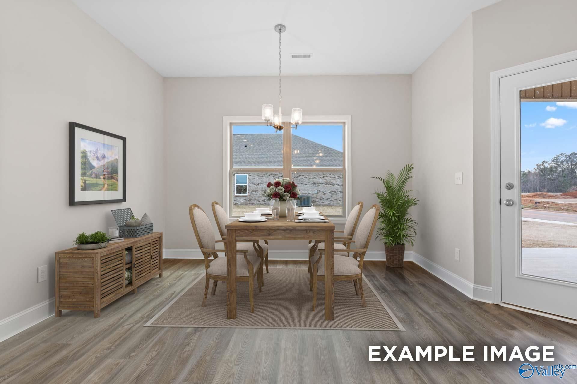 Elegant dining room with wooden table, upholstered chairs, chandelier, and large windows in The Everett 4-bedroom home, Meridianville, Alabama