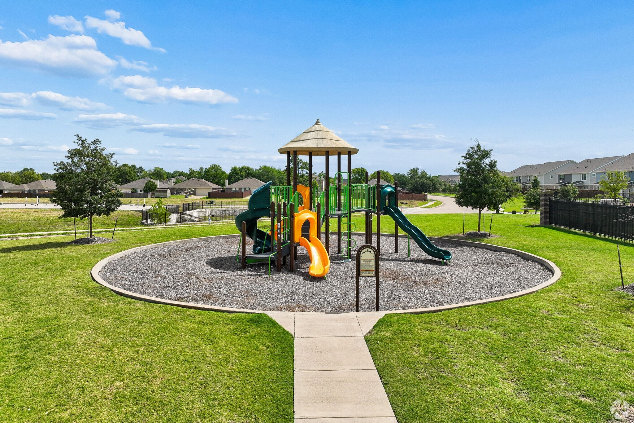 Community playground at Lake Park Villas in Wylie, Texas, featuring a central climbing structure and slides.