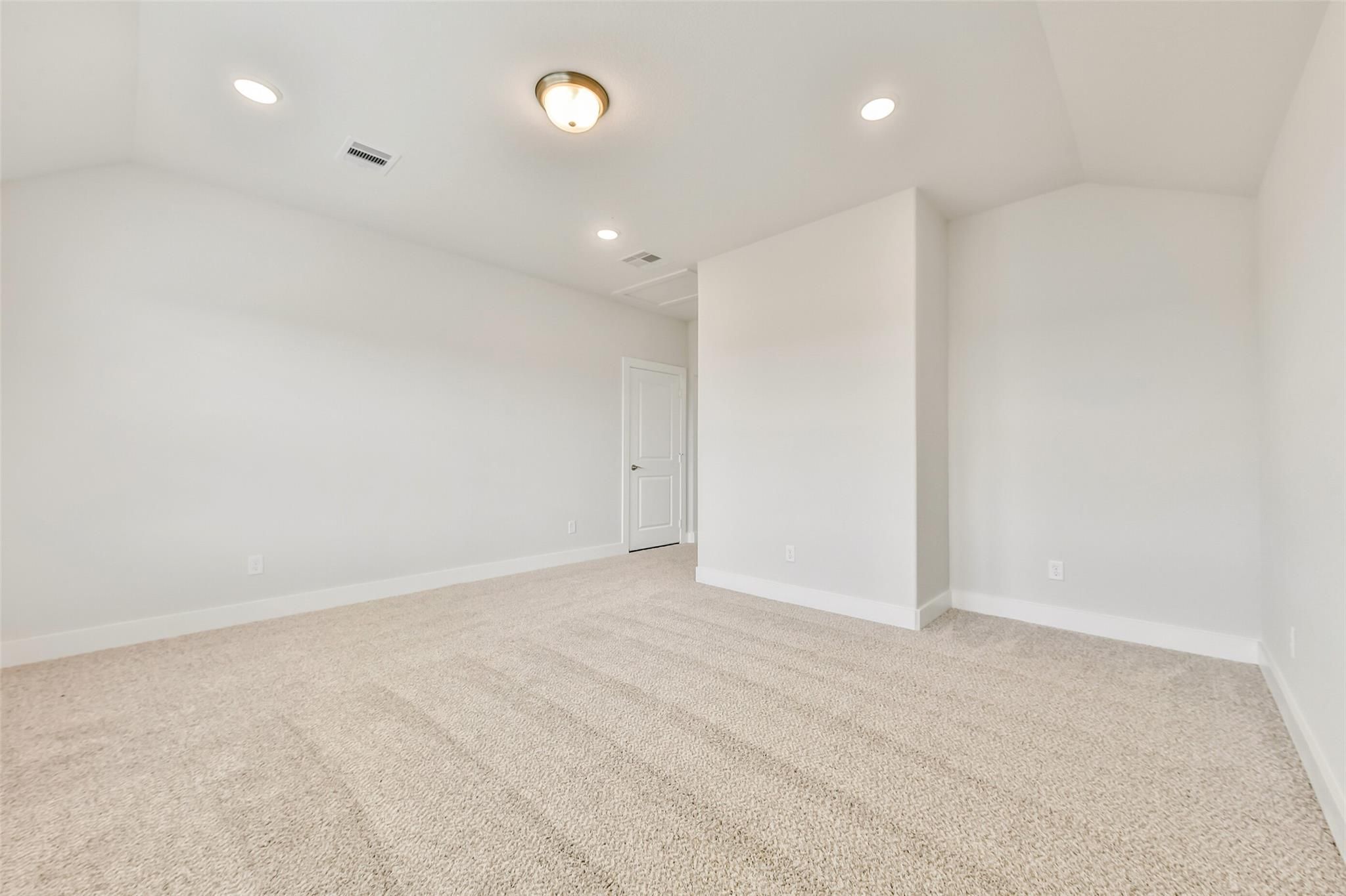 Spacious empty bedroom with beige carpet, white walls, recessed lights in Davidson Homes The Victoria A, Lago Mar, Texas City