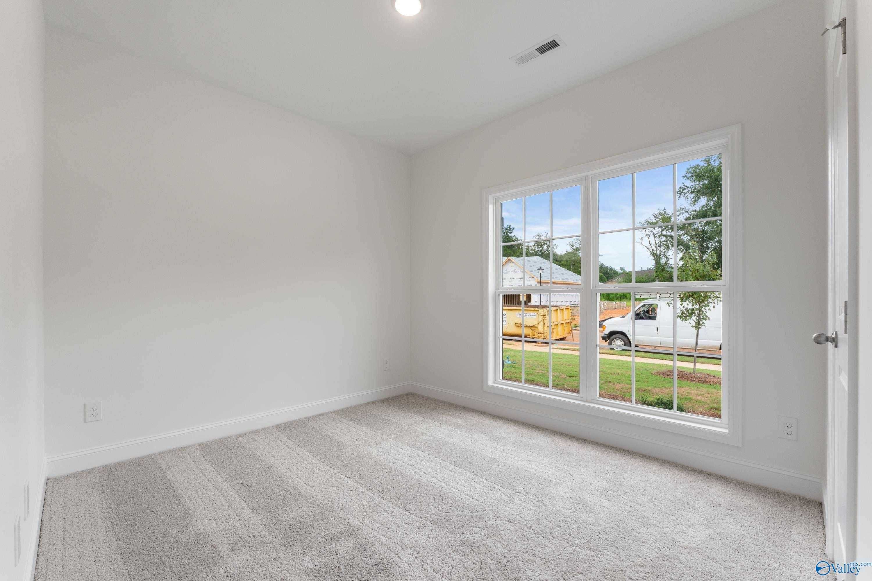Bright secondary bedroom with large window view of neighborhood in Davidson Homes The Asheville C, New Market, Alabama