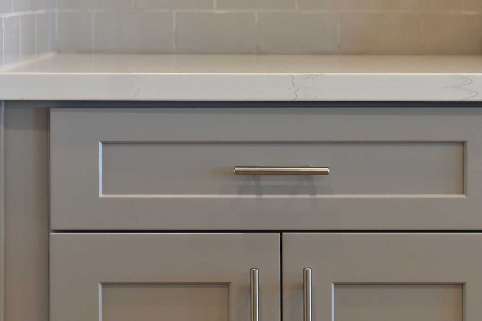 Modern gray shaker cabinets with white quartz countertop in The Harmony kitchen by Davidson Homes