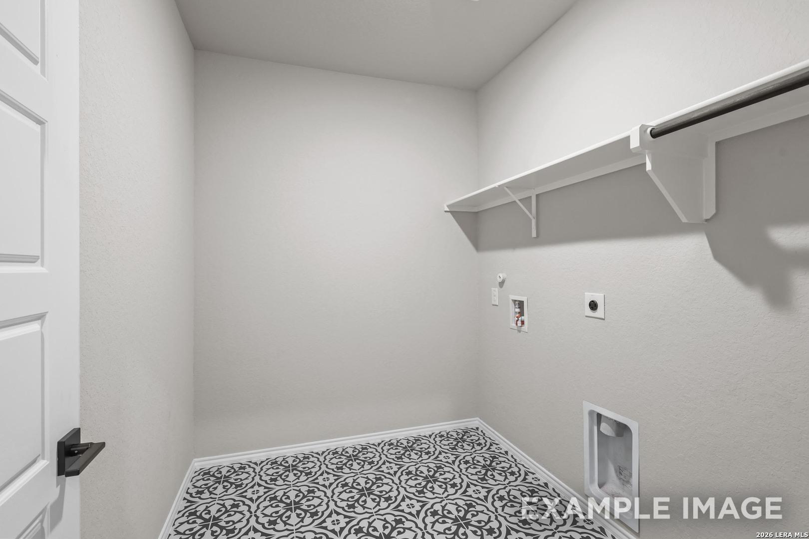 Laundry room with patterned tile floor, white shelving, and washer connections in Davidson Homes The Murray H, Converse, Texas