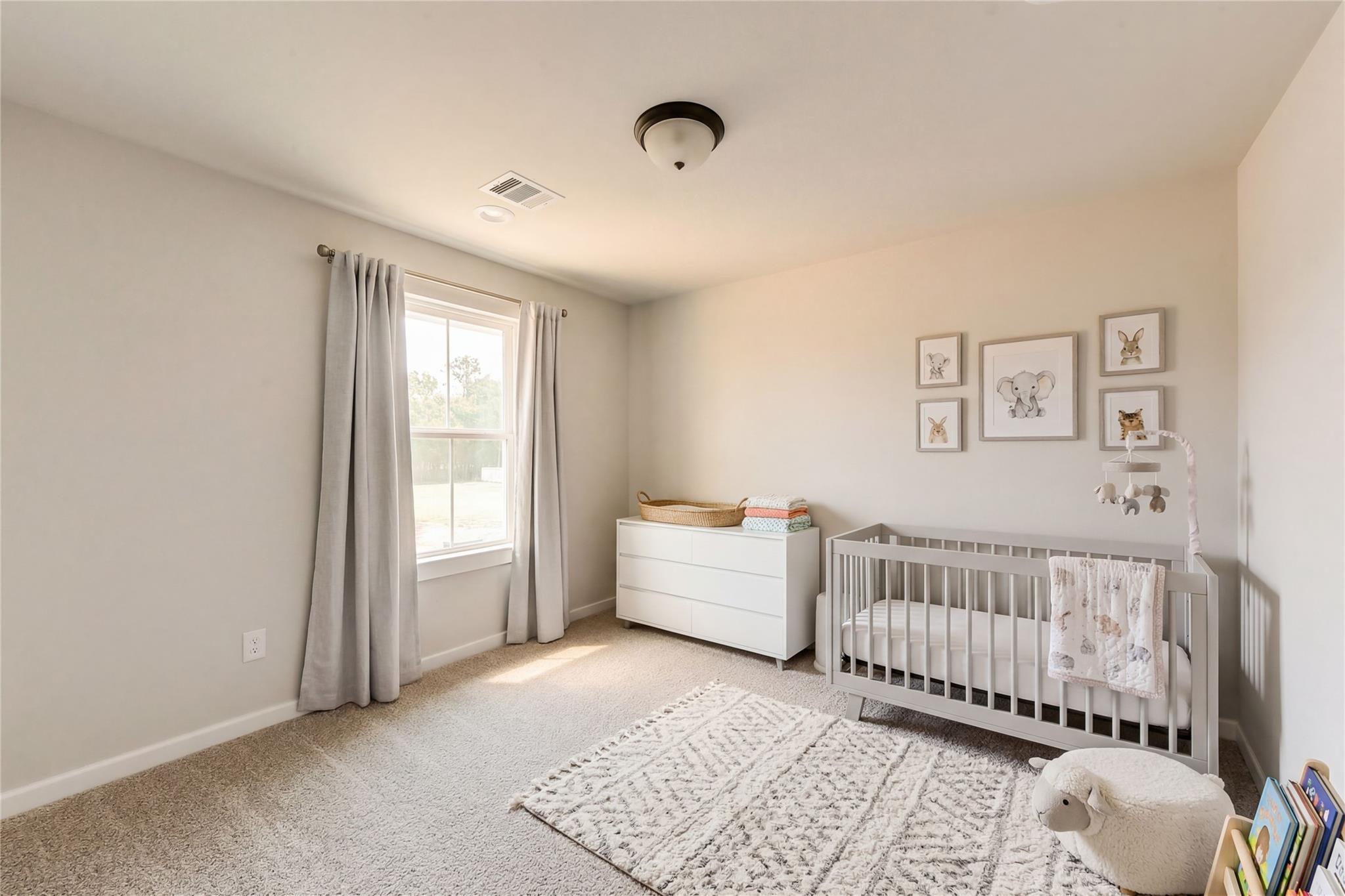 Cozy nursery with gray crib, elephant mobile, animal artwork, and plush sheep in Davidson Homes Sequoia C, Crosby, Texas