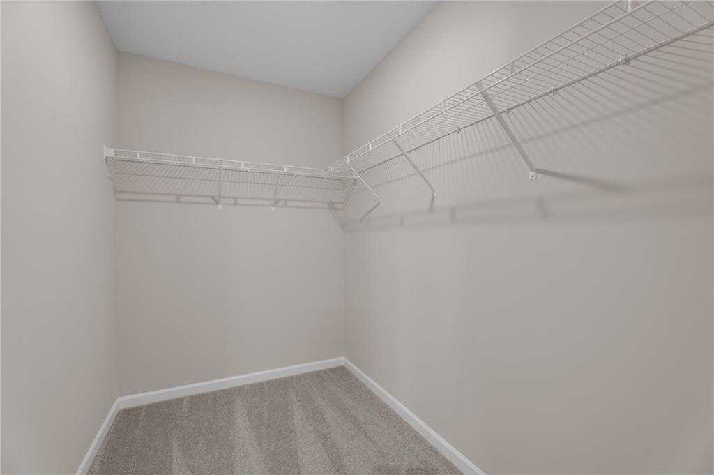 Spacious walk-in closet with wire shelving on beige walls in Davidson Homes The Bartlett, Phenix City, Alabama