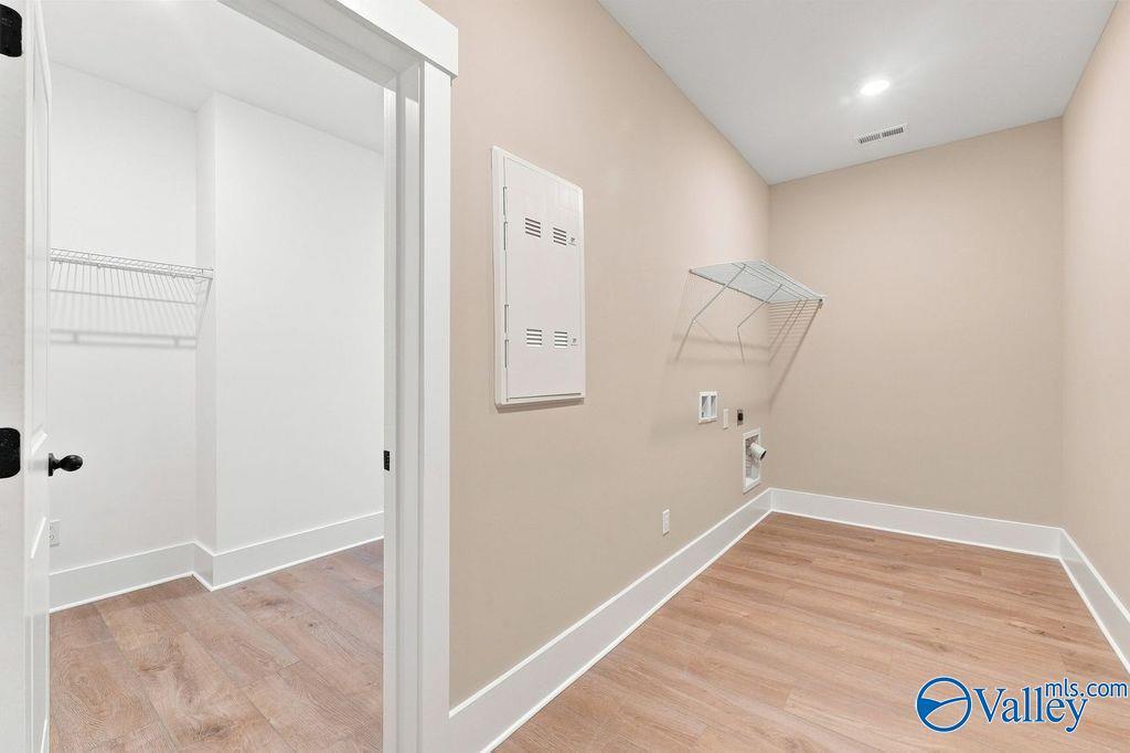 Laundry room with shelving and wood-style flooring in The Rockford floor plan by Davidson Homes in Cain Park, Hartselle, AL.