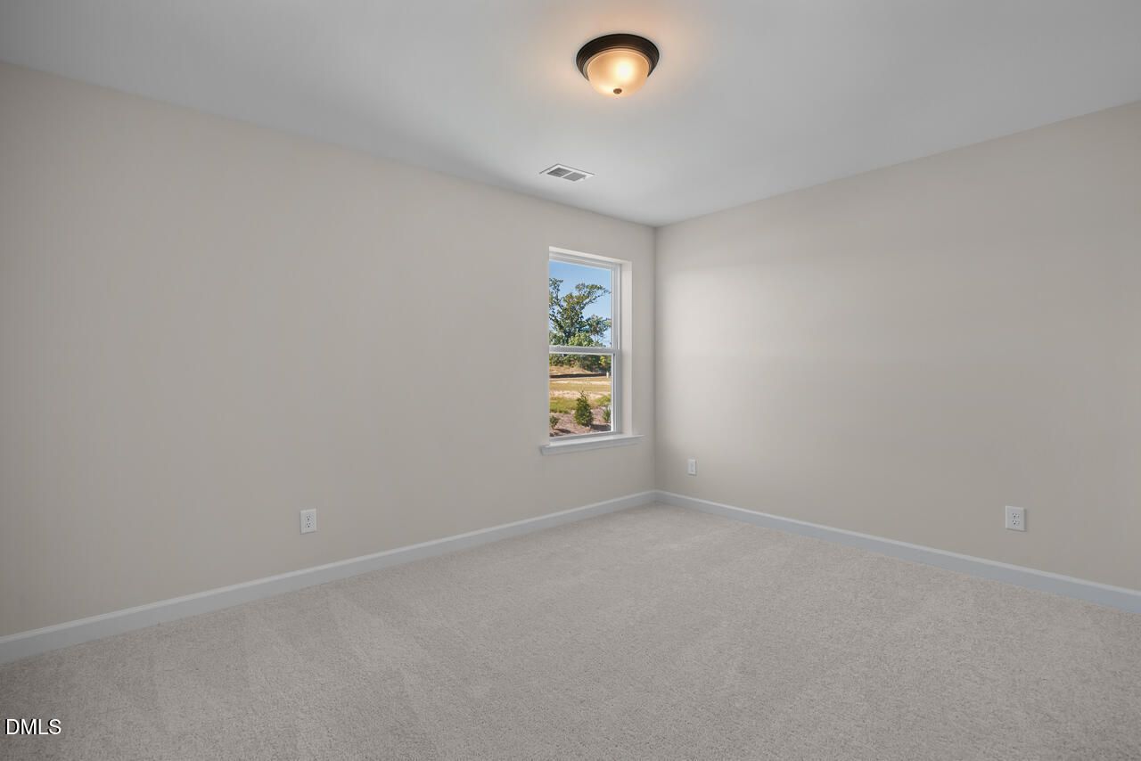 Bright bedroom with carpet and window view in Davidson Homes The Ashport M, Wendell Ridge, Wendell, North Carolina