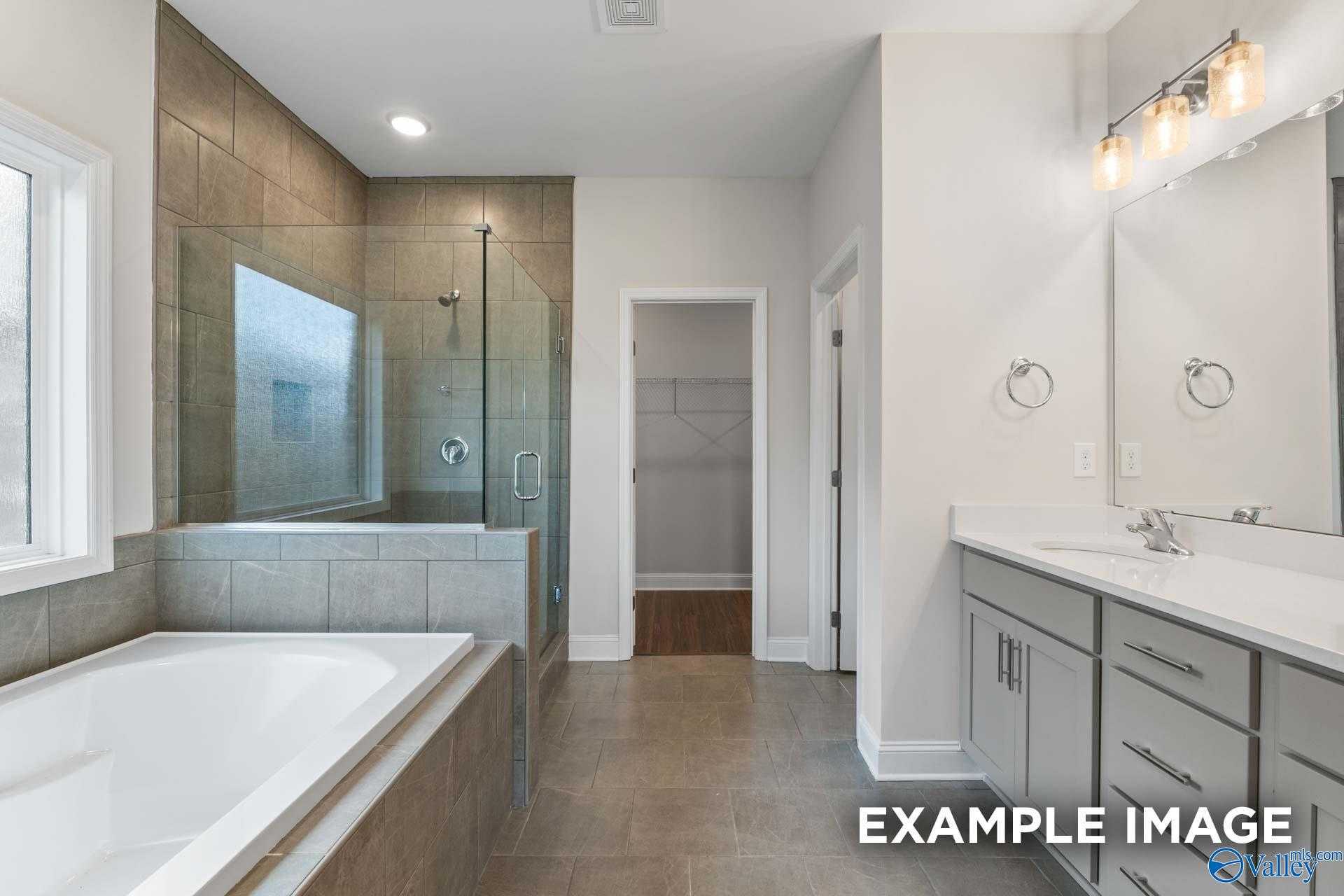 Modern master bathroom featuring glass shower, soaking tub, and double vanity in Davidson Homes The Montgomery, Athens, Alabama
