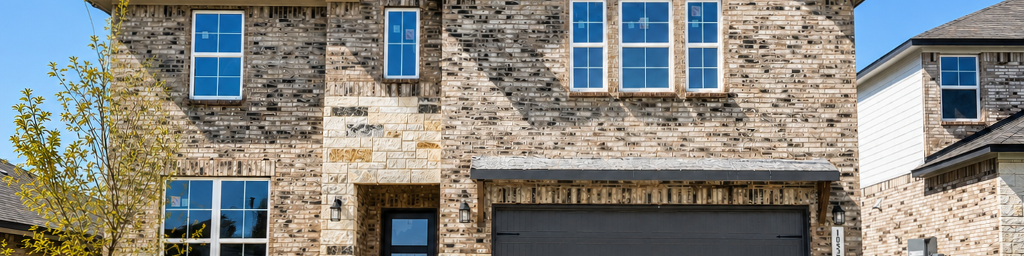 Davidson Homes exterior featuring brick and stone facade at The Parks at Foster Crossing in Anna, Texas.