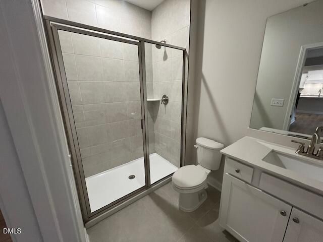 Modern bathroom with tiled walk-in shower, toilet, and white vanity in The Willow D by Davidson Homes, Lillington, NC
