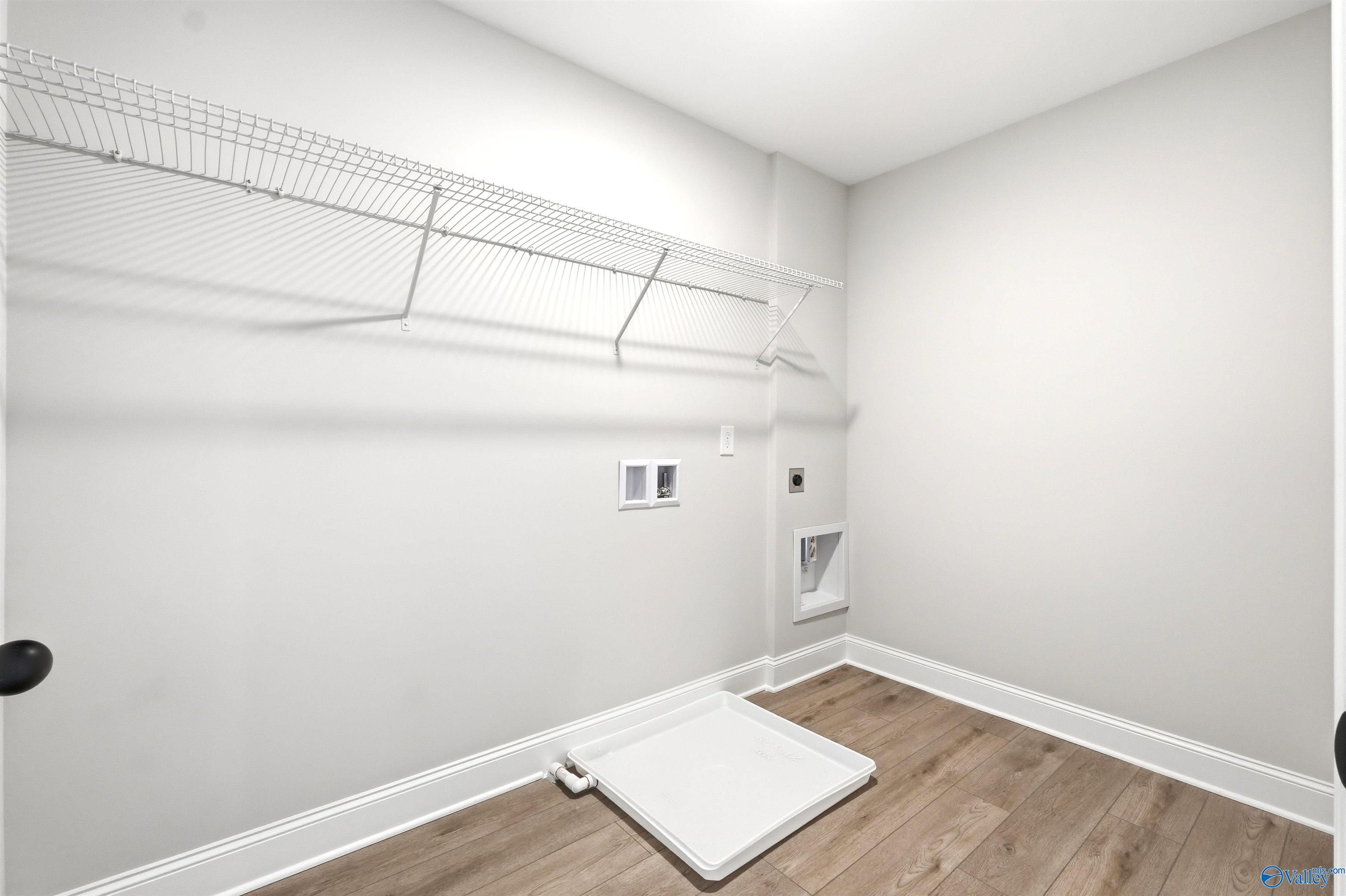 Laundry room with white wire shelving and washer hookups in The Shelby A floor plan at Wood Trail in Toney, Alabama.