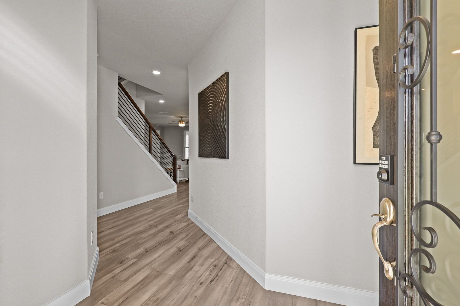 Bright entryway of The Jennings F floor plan featuring light wood flooring and a staircase leading to the second story.